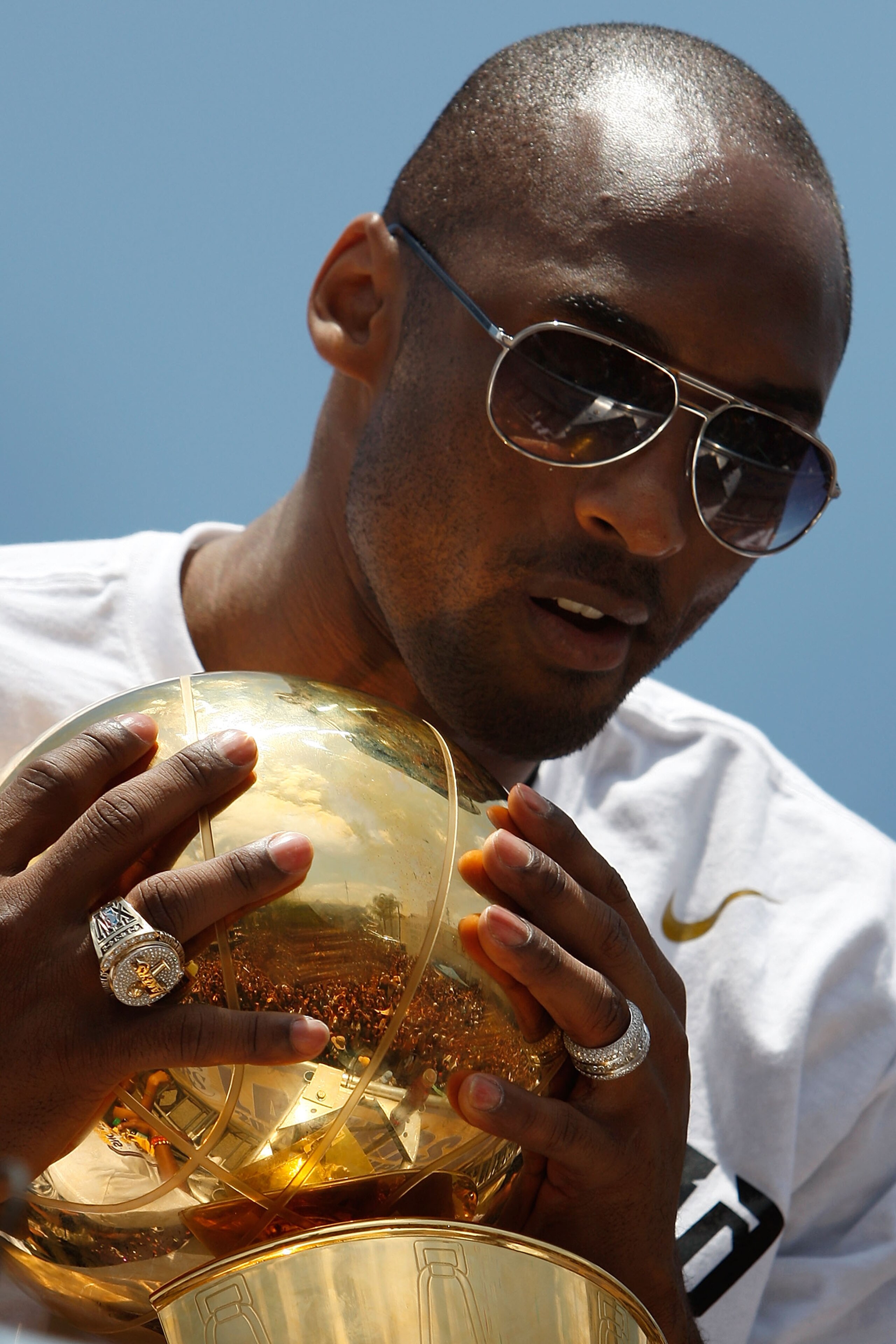 LOS ANGELES, CA - JUNE 21:  The crowd is reflected in the championship trophy held by Los Angeles Lakers guard Kobe Bryant as he rides in the victory parade for the the NBA basketball champion team on June 21, 2010 in Los Angeles, California. The Lakers b