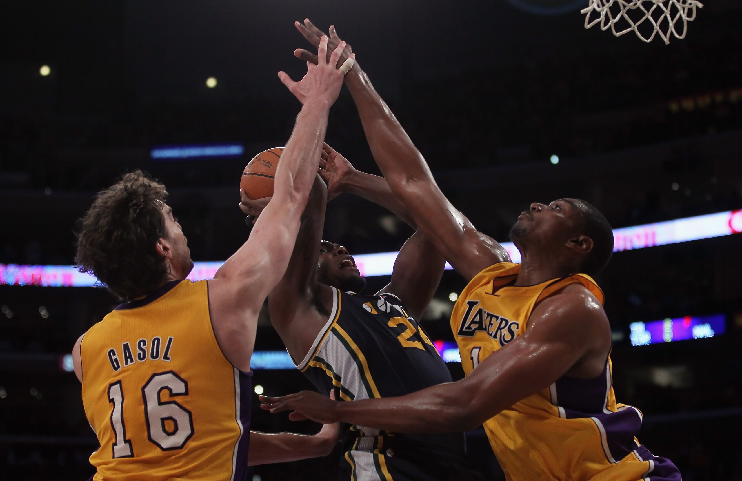 LOS ANGELES, CA - JANUARY 25:   Pau Gasol (L) #16 and Andrew Bynum (R) #17 the Los Angeles Lakers tie up Paul Millsap (center) #24 of the Utah Jazz in the first half at Staples Center on January 25, 2011 in Los Angeles, California. NOTE TO USER: User expr
