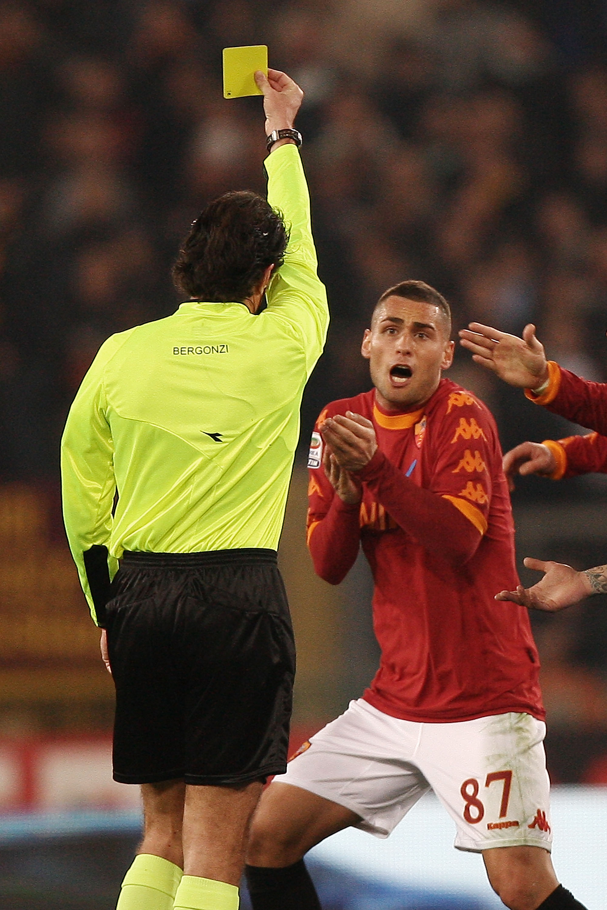 ROME, ITALY - FEBRUARY 12:  The referee Mauro Bergonzi (L) shows the yellow card to Aleandro Rosi of AS Roma during the Serie A match between AS Roma and SSC Napoli at Stadio Olimpico on February 12, 2011 in Rome, Italy.  (Photo by Paolo Bruno/Getty Image