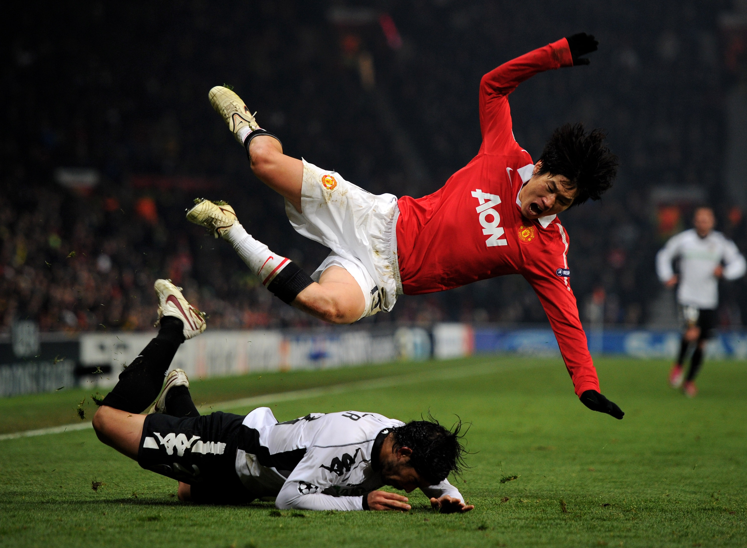 MANCHESTER, ENGLAND - DECEMBER 07:  Ever Banega of Valencia brings down Ji-Sung Park of Manchester United during the UEFA Champions League Group C match between Manchester United and Valencia at Old Trafford on December 7, 2010 in Manchester, England.  (P