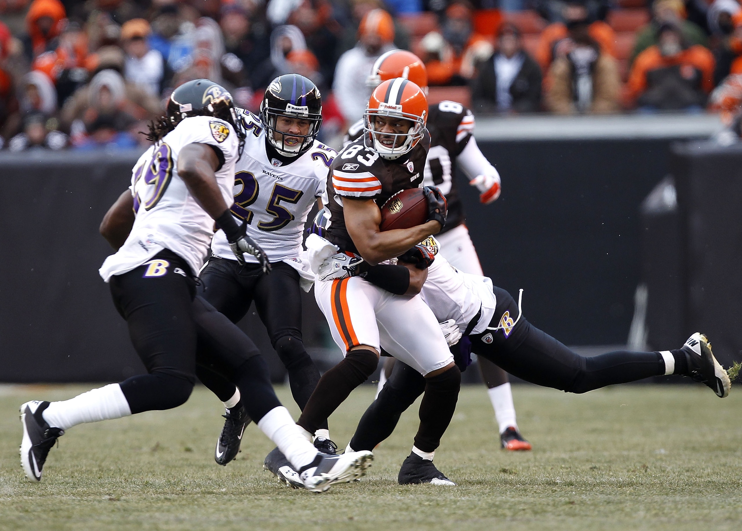 CLEVELAND - DECEMBER 26:  Defenders Dannell Ellerbe #59, Chris Carr #25 and Lardarius Webb #21 of the Baltimore Ravens tackle wide receiver Chansi Stuckey #83 of the Cleveland Browns at Cleveland Browns Stadium on December 26, 2010 in Cleveland, Ohio.  (P