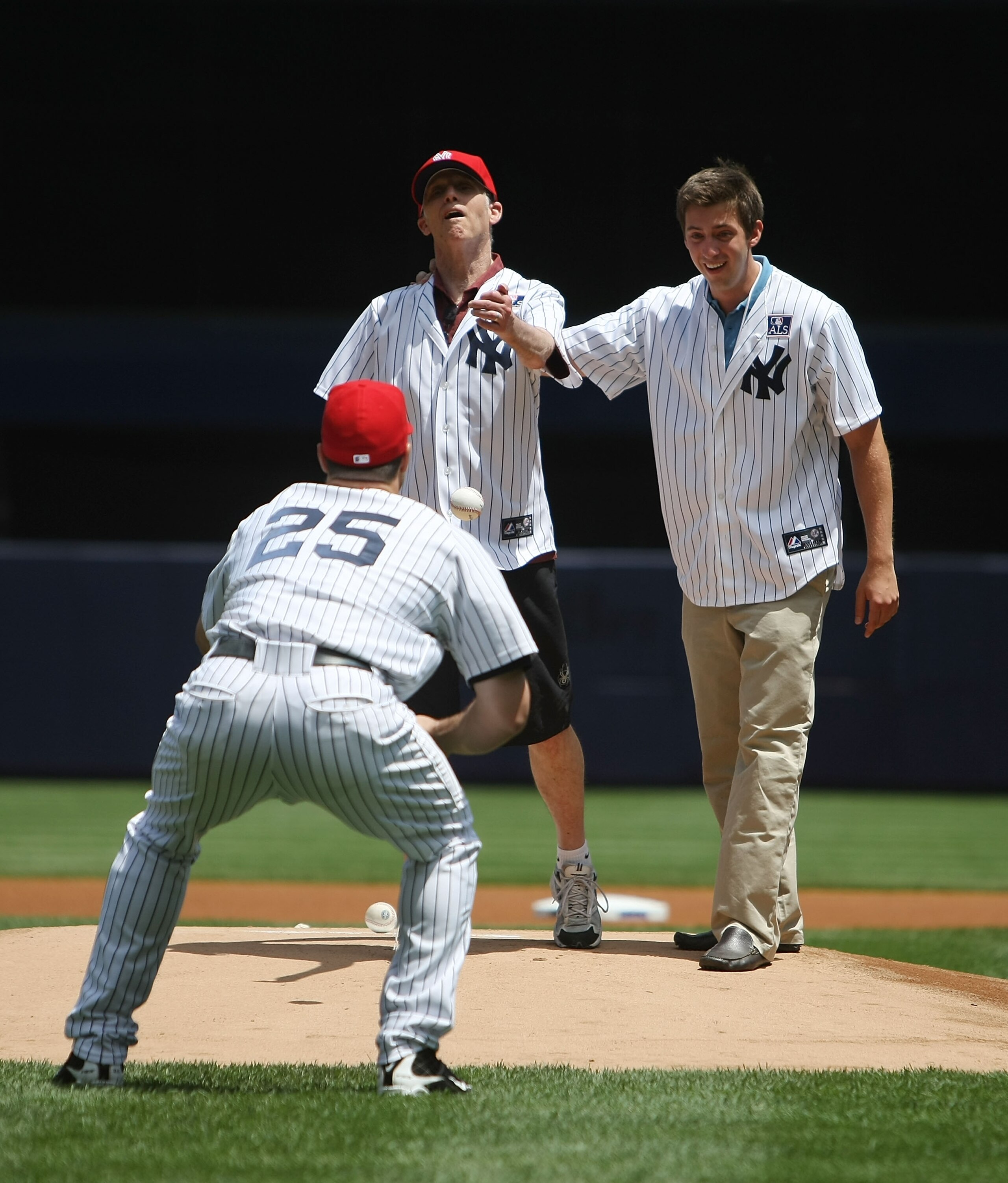 NEW YORK - JULY 04: Michael Goldsmith, a sufferer of  Amyotrophic Lateral Sclerosis (ALS), often referred to as 'Lou Gehrig's Disease', throws out the first pitch with son Austin and Mark Teixeira #25 of the New York Yankees prior to the game against the