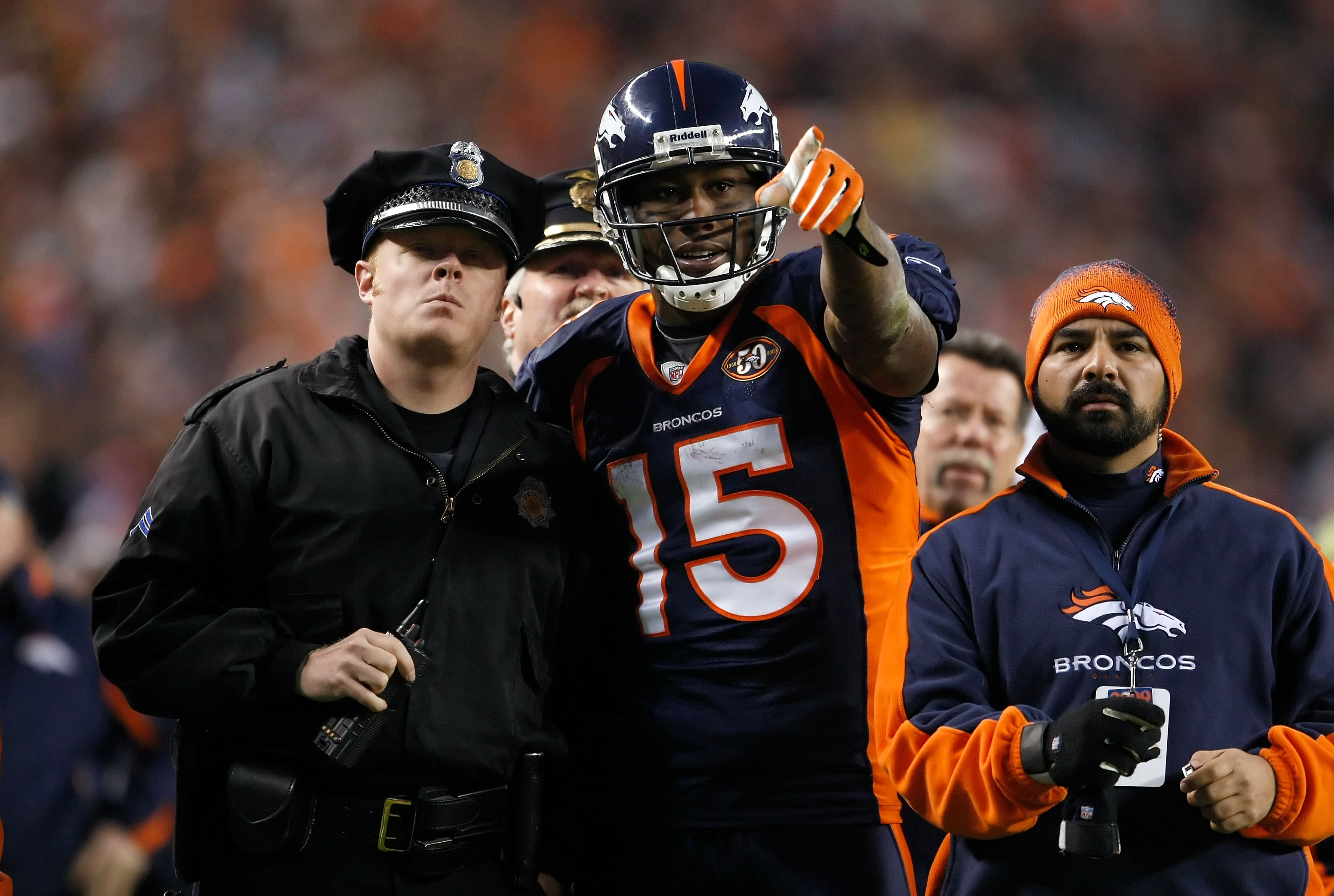 DENVER - DECEMBER 20:  Brandon Marshall #15 of the Denver Broncos points out a disturbance in the crowd to a police officer in the second half against the Oakland Raiders at Invesco Field at Mile High on December 20, 2009 in Denver, Colorado. The Raiders