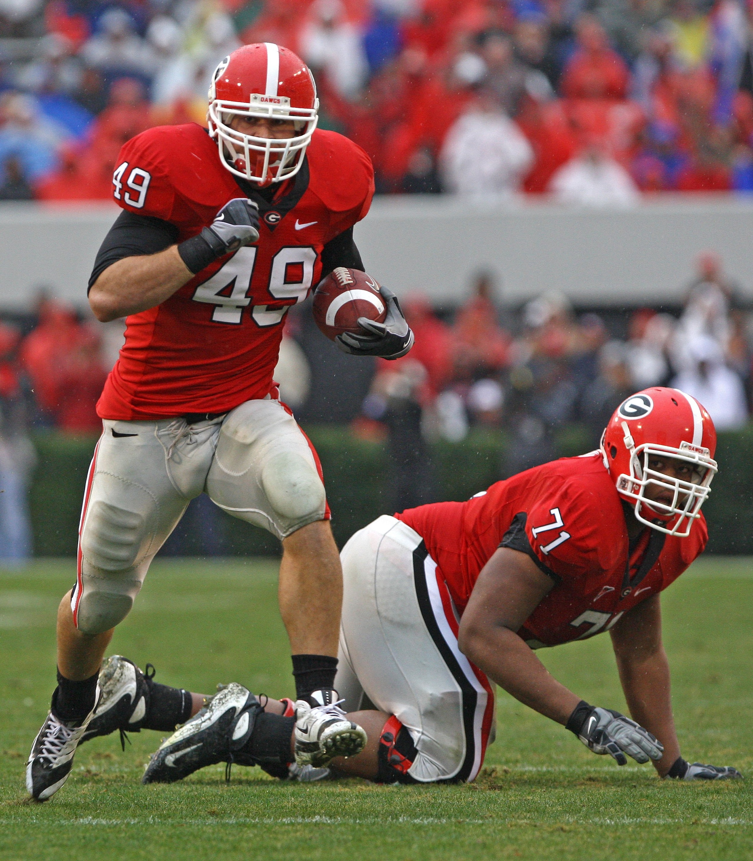 ATHENS, GA - NOVEMBER 29:  Fullback Shaun Chapas #49 of the Georgia Bulldogs runs upfield as teammate and offensive lineman Cordy Glenn watches during the game against the Georgia Tech Yellow Jackets at Sanford Stadium on November 29, 2008 in Athens, Geor