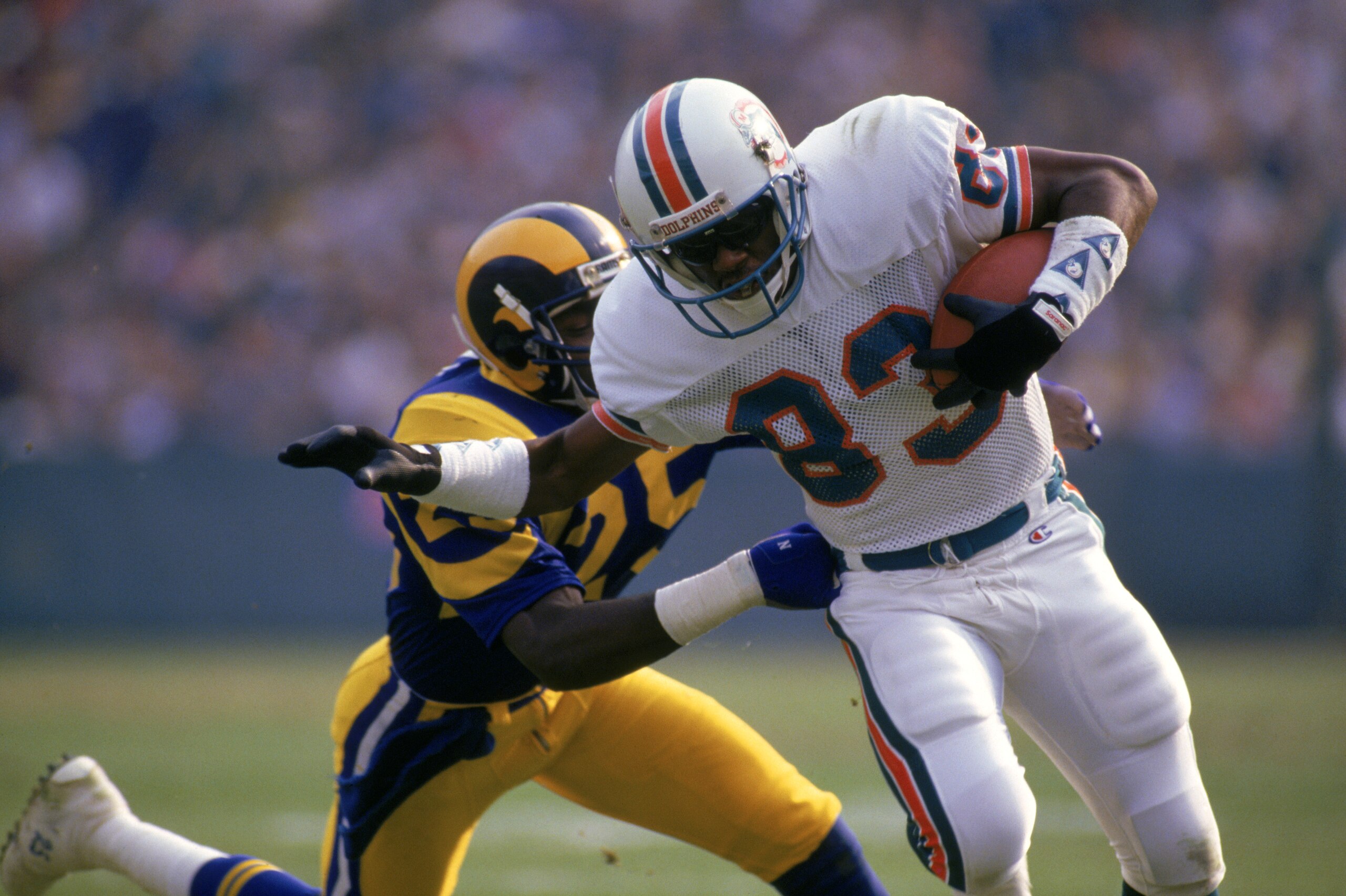 ANAHEIM, CA - DECEMBER 14: Wide receiver Mark Clayton #83 of the Miami Dolphins tries to break a tackle by defensive back Jerry Gray #25 of the Los Angeles Rams during a game at Anaheim Stadium on December 14, 1986 in Anaheim, California. The Dolphins ANAHEIM, CA - DECEMBER 14: Wide receiver Mark Clayton #83 of the Miami Dolphins tries to break a tackle by defensive back Jerry Gray #25 of the Los Angeles Rams during a game at Anaheim Stadium on December 14, 1986 in Anaheim, California. The Dolphins