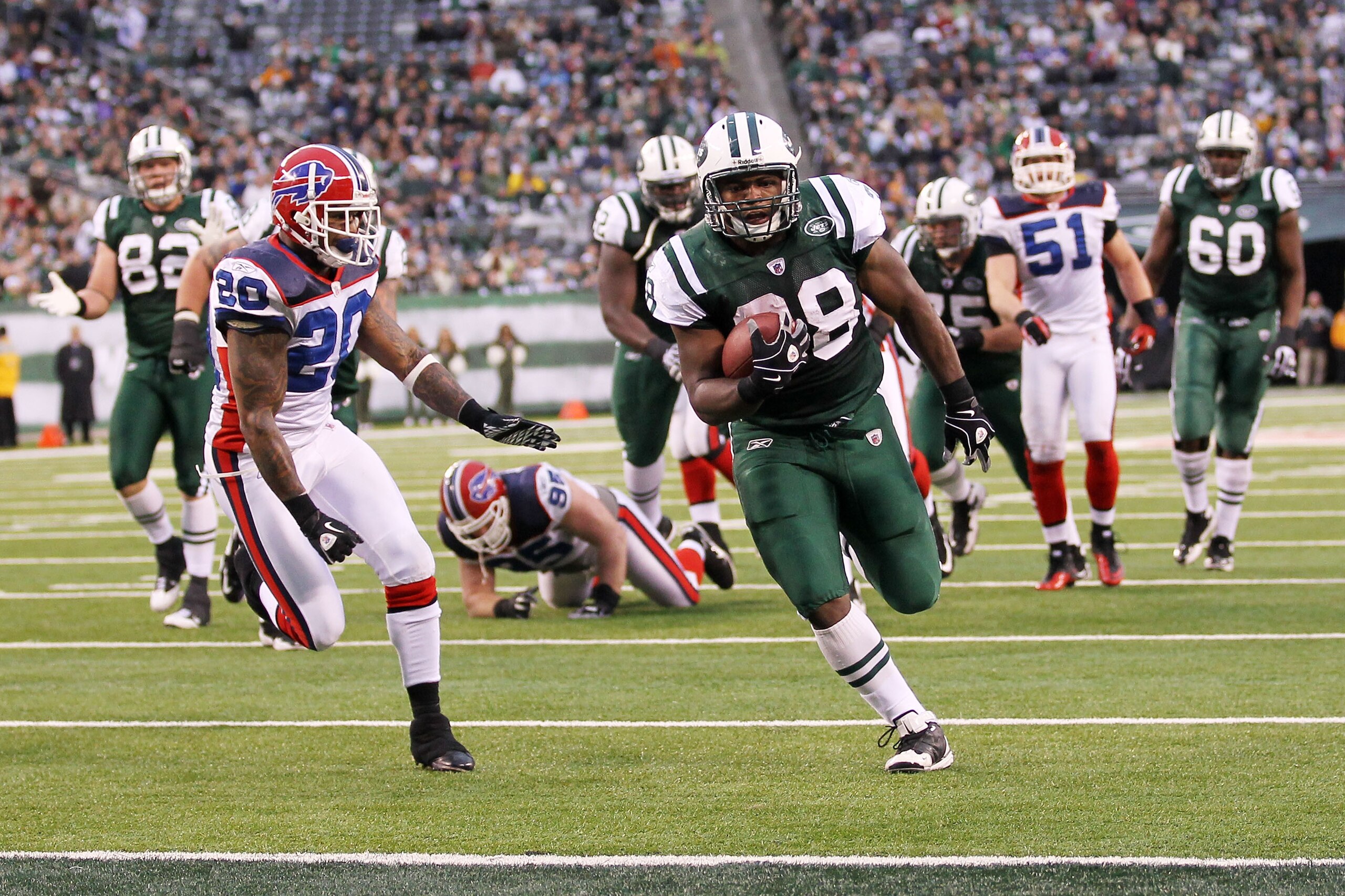 EAST RUTHERFORD, NJ - JANUARY 02:  John Conner #38 of the New York Jets runs for a touchdown against the defense of Donte Whitner #20 of the Buffalo Bills at New Meadowlands Stadium on January 2, 2011 in East Rutherford, New Jersey.  (Photo by Al Bello/Ge
