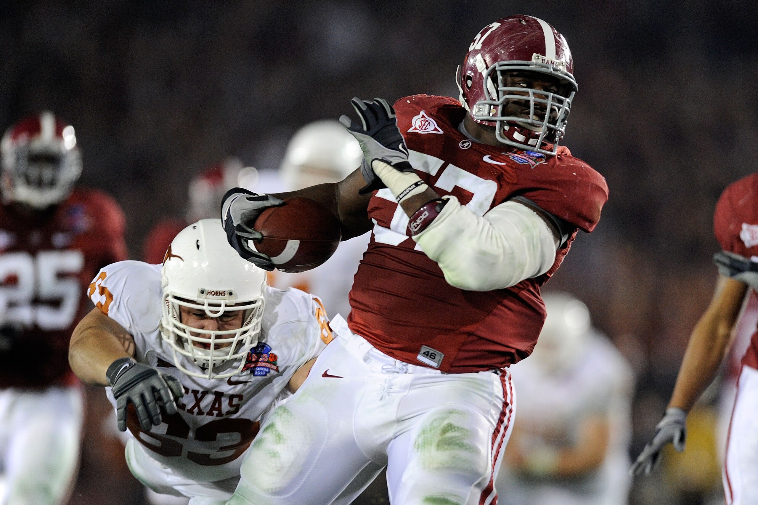 PASADENA, CA - JANUARY 07: Lineman Marcell Dareus #57 of the Alabama Crimson Tide runs with the ball after an interception as guard Michael Huey #63 of the Texas Longhorns attempts to tackle during the second quarter of the Citi BCS National Championship PASADENA, CA - JANUARY 07: Lineman Marcell Dareus #57 of the Alabama Crimson Tide runs with the ball after an interception as guard Michael Huey #63 of the Texas Longhorns attempts to tackle during the second quarter of the Citi BCS National Championship