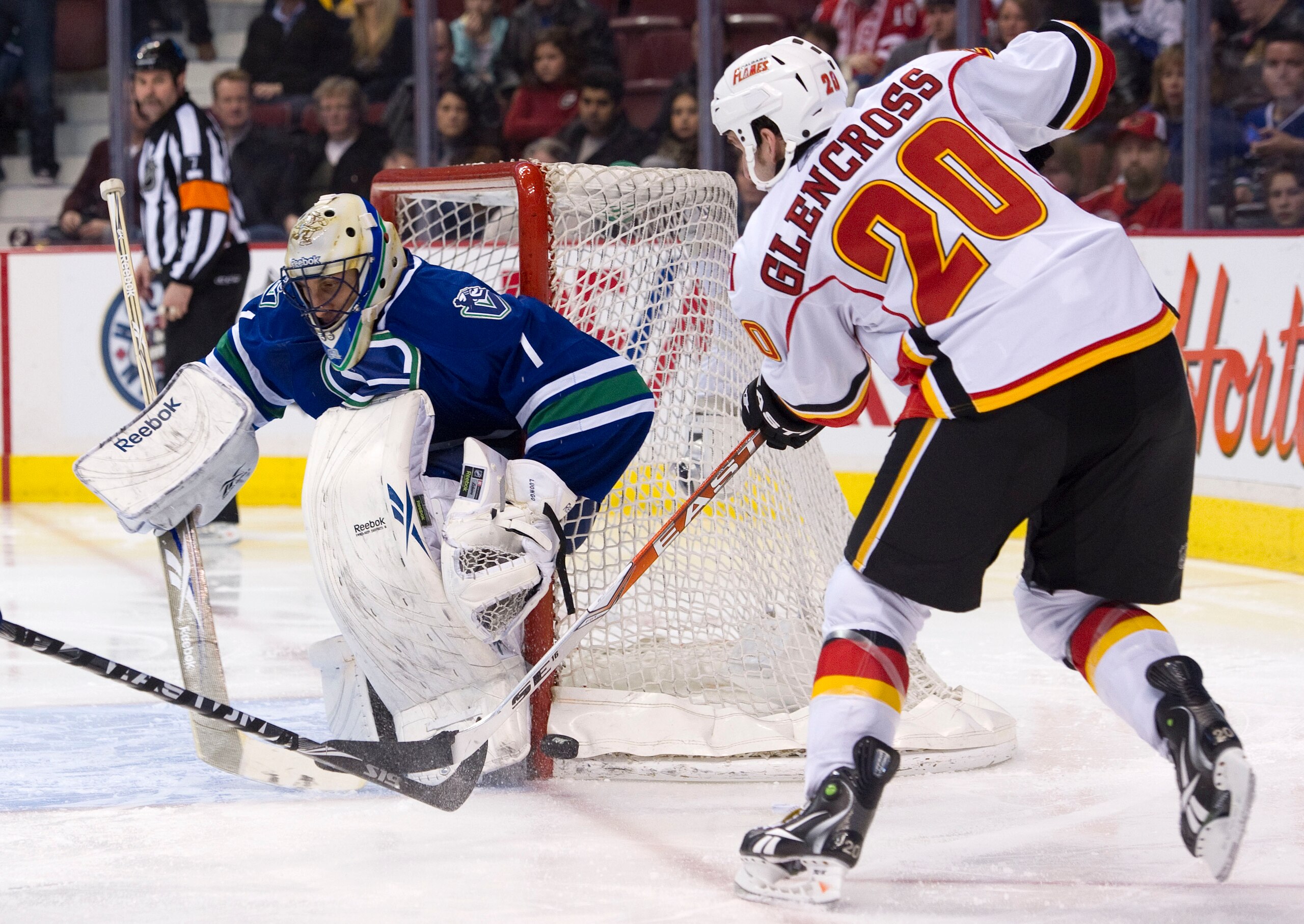 VANCOUVER, CANADA - FEBRUARY 12: Curtis Glencross #20 of the Calgary Flames is stopped by goalie Roberto Luongo #1 of the Vancouver Canucks during the third period in NHL action on February 12, 2011 at Rogers Arena in Vancouver, British Columbia, Canada.