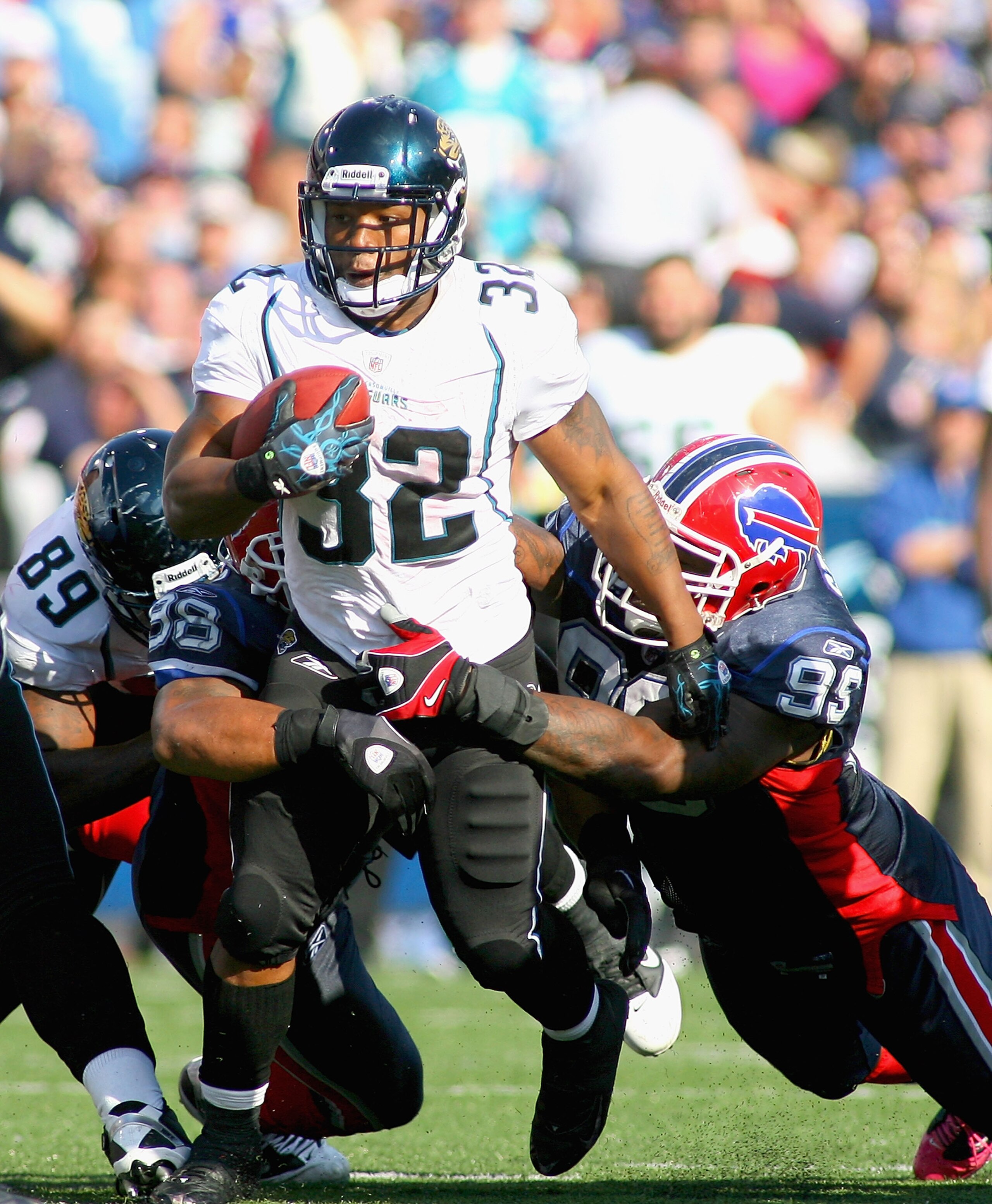 ORCHARD PARK, NY - OCTOBER 10:  Maurice Jones-Drew #32 of the Jacksonville Jaguars runs as Dwan Edwards #98 and Marcus Stroud #99 of  the Buffalo Bills try to tackle him at Ralph Wilson Stadium on October 10, 2010 in Orchard Park, New York. Jacksonville w