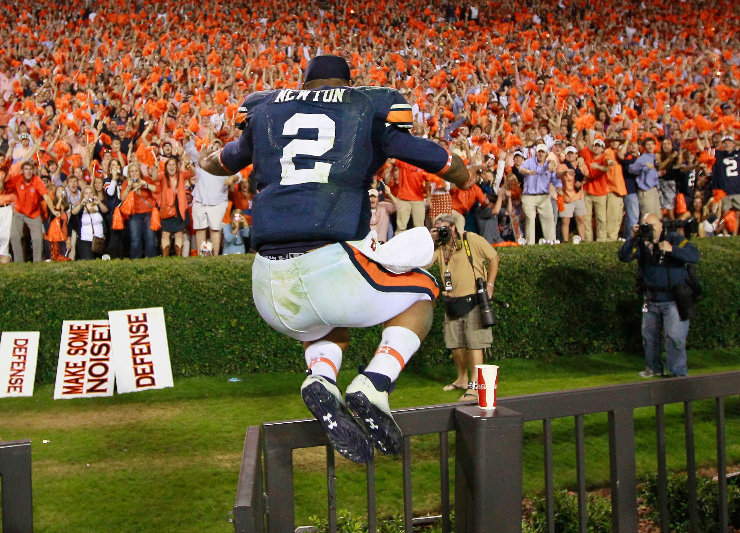 AUBURN, AL - NOVEMBER 13:  Quarterback Cameron Newton #2 of the Auburn Tigers leaps over a fence as he clebrates with fans after their 49-31 win over the Georgia Bulldogs at Jordan-Hare Stadium on November 13, 2010 in Auburn, Alabama.  (Photo by Kevin C. 