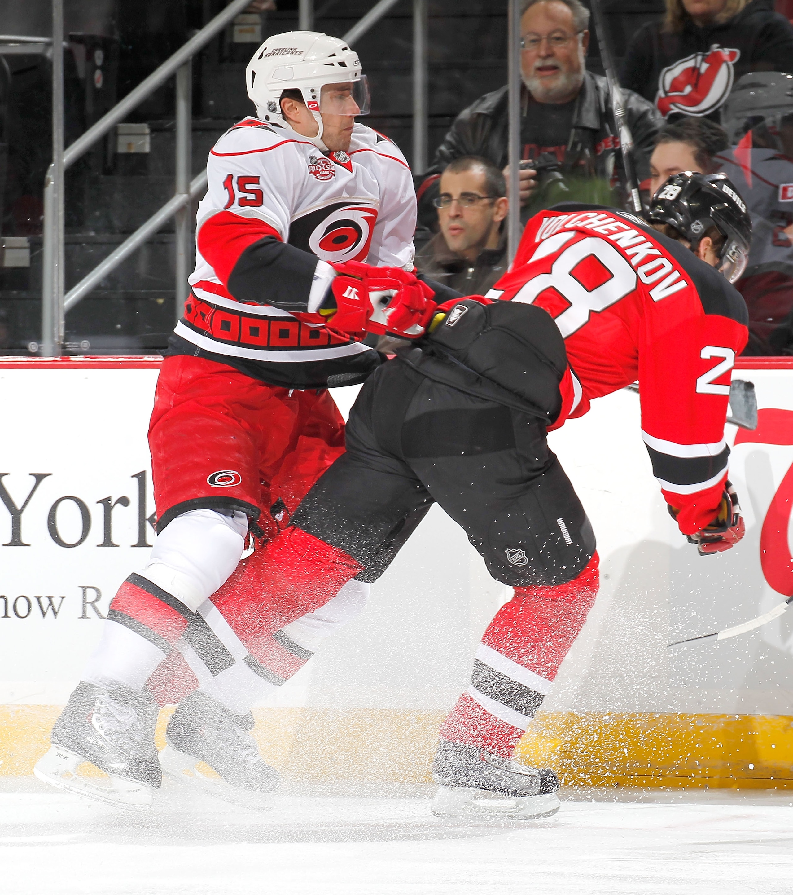 NEWARK, NJ - FEBRUARY 08:   Tuomo Ruutu #15 of the Carolina Hurricanes checks Anton Volchenkkov #28 of the New Jersey Devils during the first period of an NHL hockey game at the Prudential Center on February 8, 2011 in Newark, New Jersey.  (Photo by Paul