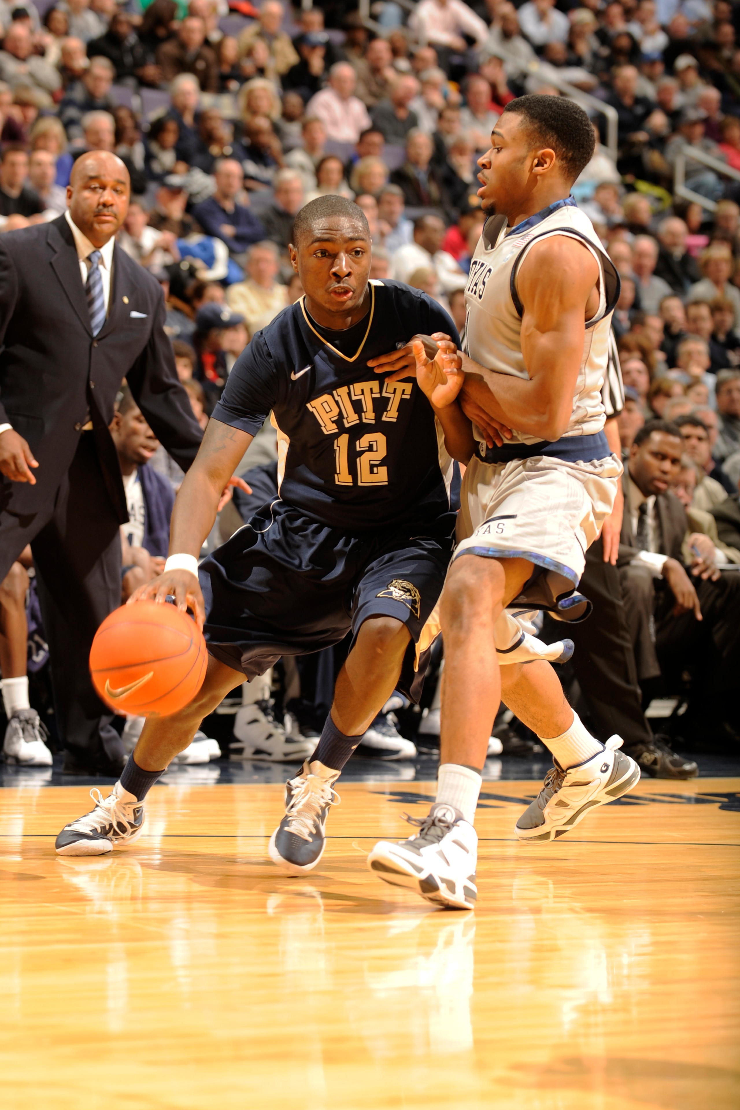 WASHINGTON, DC- JANUARY 12:  Ashton Gibbs #12 of the Pittsburgh Panthers dribbles around Vee Sanford #11 of the Georgetown Hoyas during a college basketball game on January 12, 2011 at the Verizon Center in Washington, DC.  The Panthers won 72-57.  (Photo