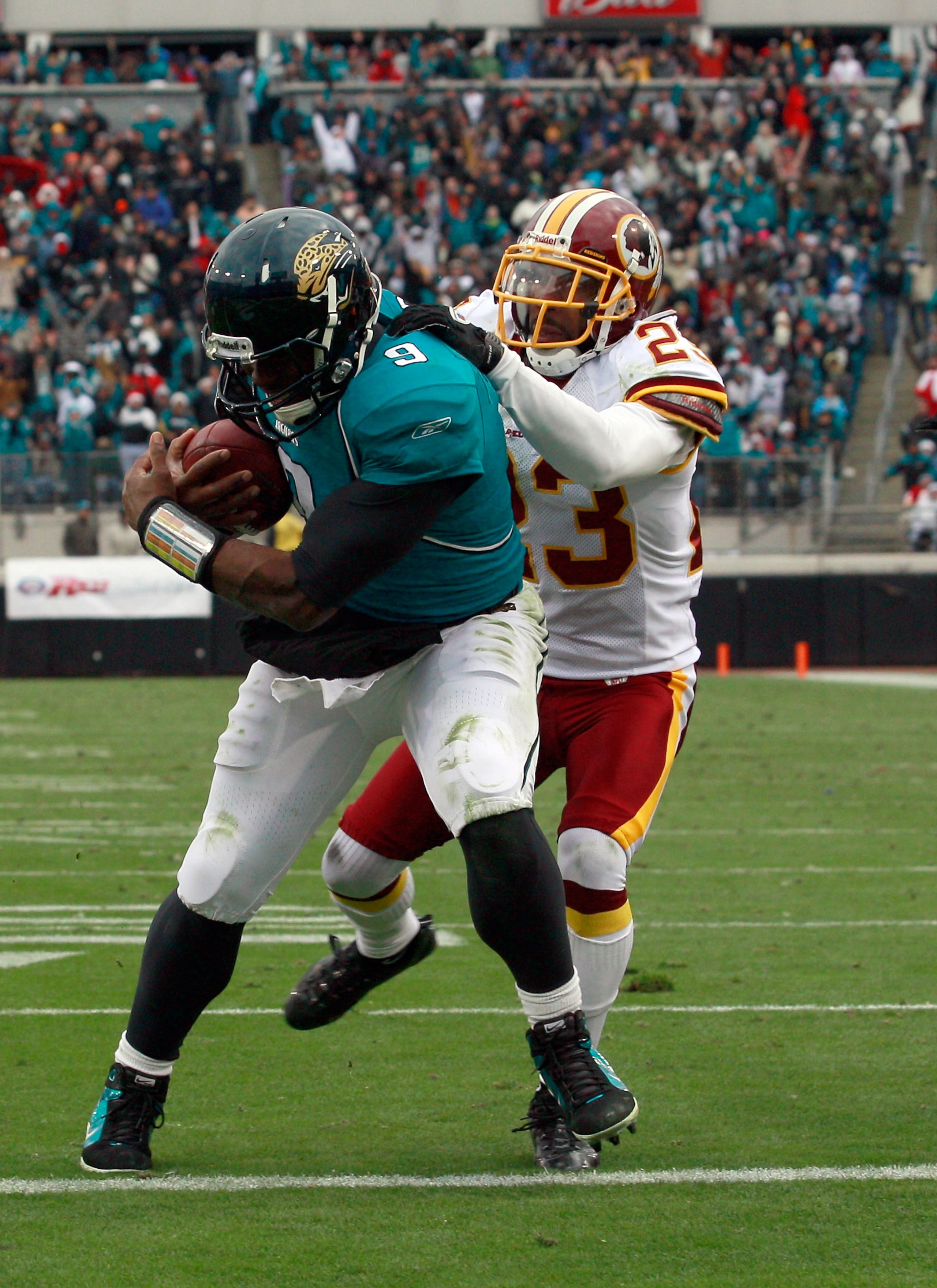 JACKSONVILLE, FL - DECEMBER 26:  DeAngelo Hall #23 of the Washington Redskins attempts to tackle Quarterback David Garrad #9 of the Jacksonville Jaguars during the game at EverBank Field on December 26, 2010 in Jacksonville, Florida.  (Photo by Sam Greenw