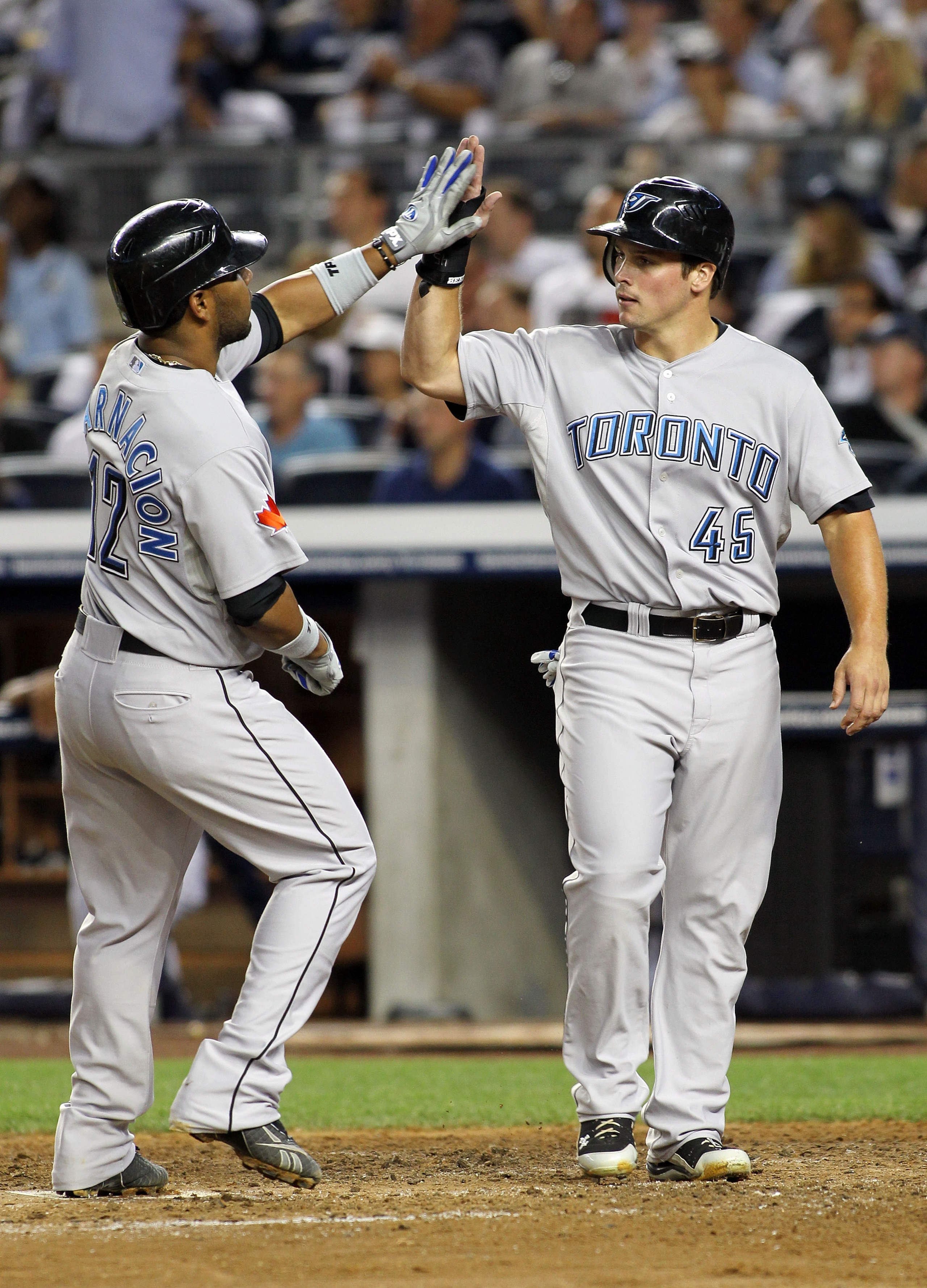 NEW YORK - AUGUST 02:  Edwin Encarnacion #12 of the Toronto Blue Jays celebrates with Travis Snider #45 after hitting a two run home run in the fifth inning against the New York Yankees on August 2, 2010 at Yankee Stadium in the Bronx borough of New York