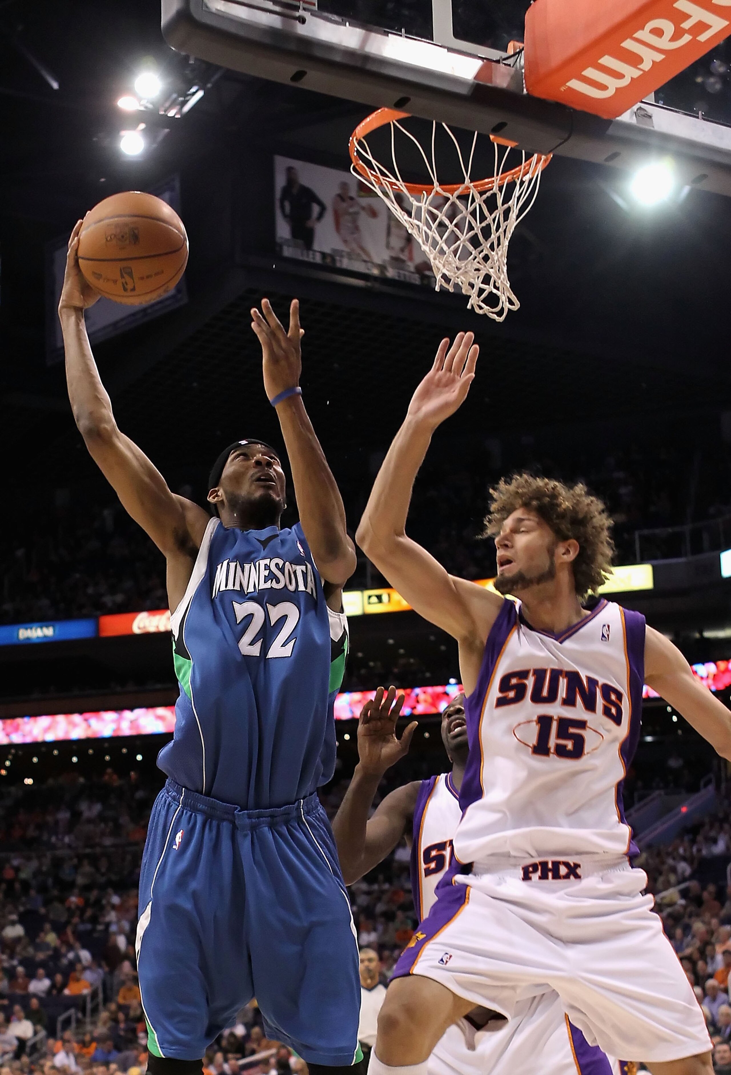 PHOENIX - MARCH 16:  Corey Brewer #22 of the Minnesota Timberwolves lays up a shot past Robin Lopez #15 of the Phoenix Suns during the NBA game at US Airways Center on March 16, 2010 in Phoenix, Arizona. The Suns defeated the Timberwolves 152-114.  NOTE T