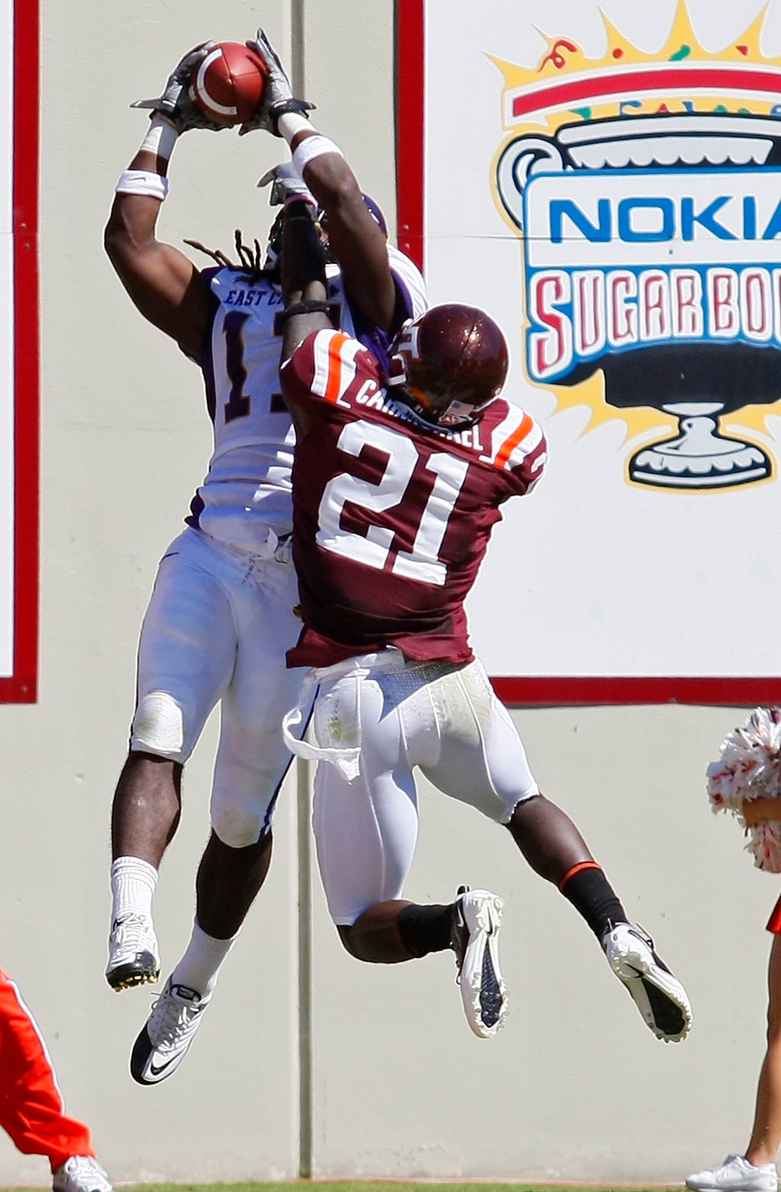 BLACKSBURG, VA - SEPTEMBER 18:  Wide receiver Dwayne Harris #17 of the East Carolina Pirates catches a touchdown pass as cornerback Rashad Carmichael #21 of the Virginia Tech Hokies defends at Lane Stadium on September 18, 2010 in Blacksburg, Virginia.  (