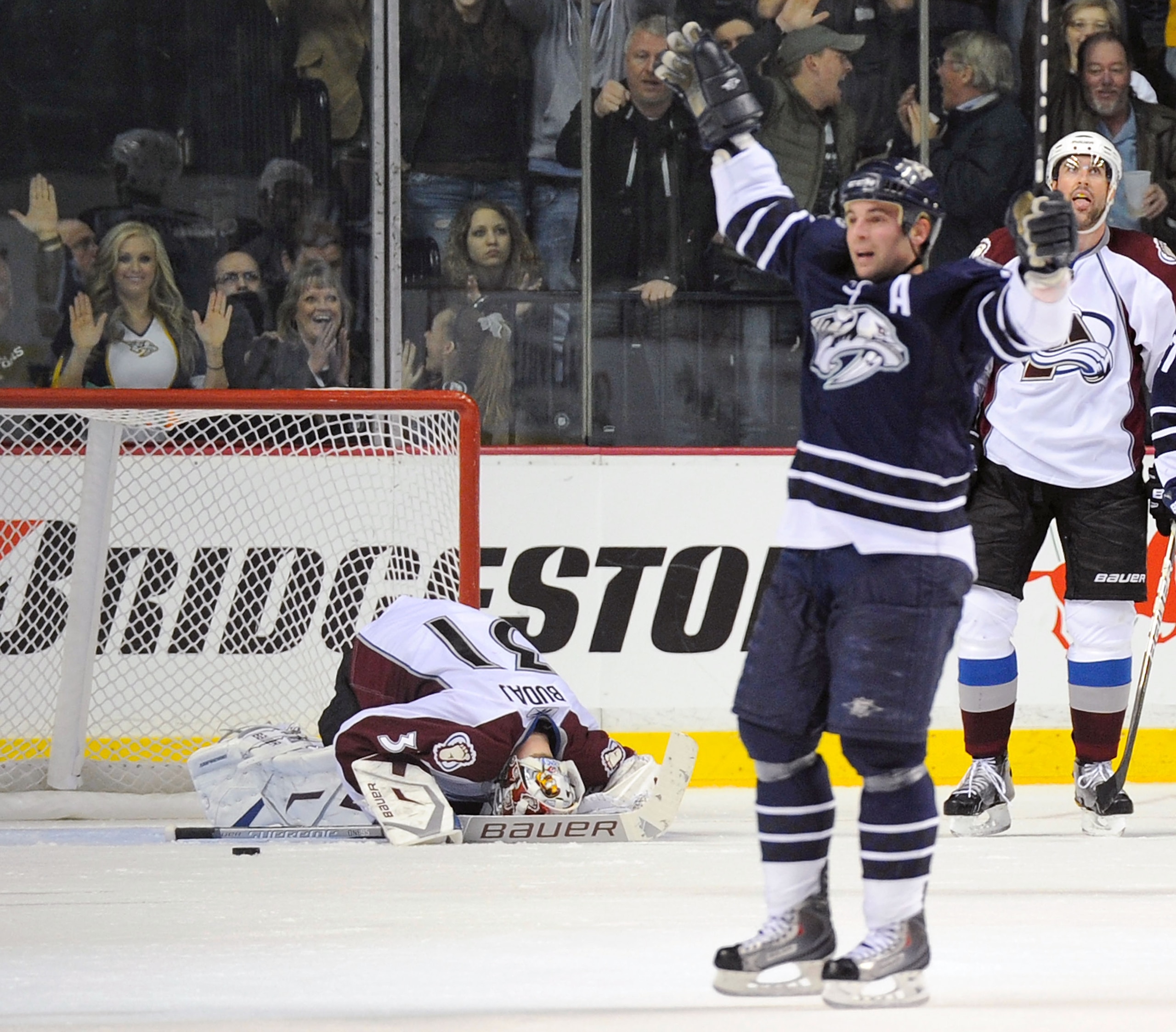 NASHVILLE, TN - FEBRUARY 12:  Goalie Peter Budaj #31 of the Colorado Avalanche lays on the ice as Steve Sullivan #26 of the Nashville Predators celebrates the go ahead goal on February 12, 2011 at the Bridgestone Arena in Nashville, Tennessee.  (Photo by