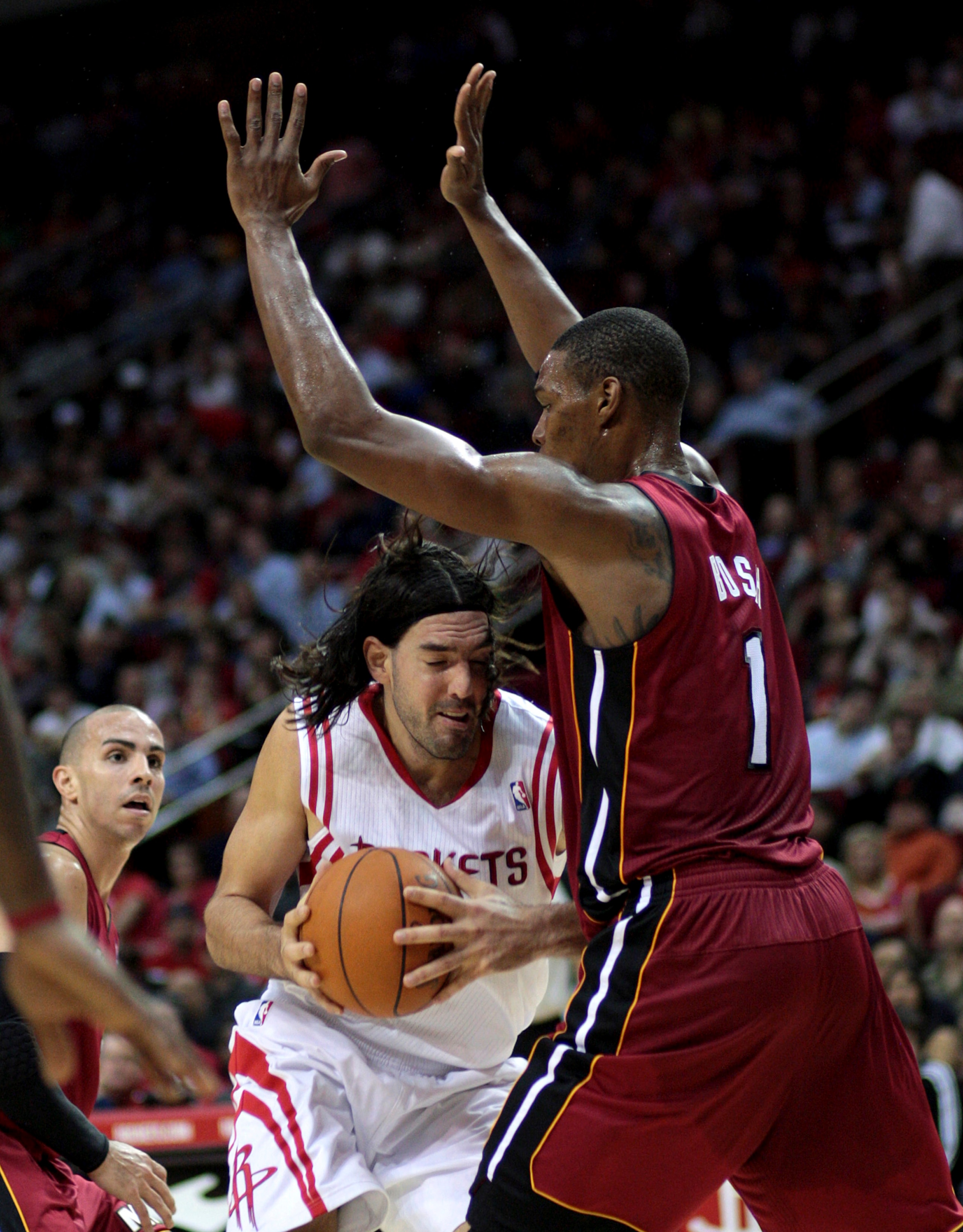 HOUSTON - DECEMBER 29: Luis Scola #4 of the Houston Rockets drives to the basket as he is fouled by Chris Bosh #1 of the Miami Heat in the third quarter at Toyota Center on December 29, 2010 in Houston, Texas.  NOTE TO USER: User expressly acknowledges an