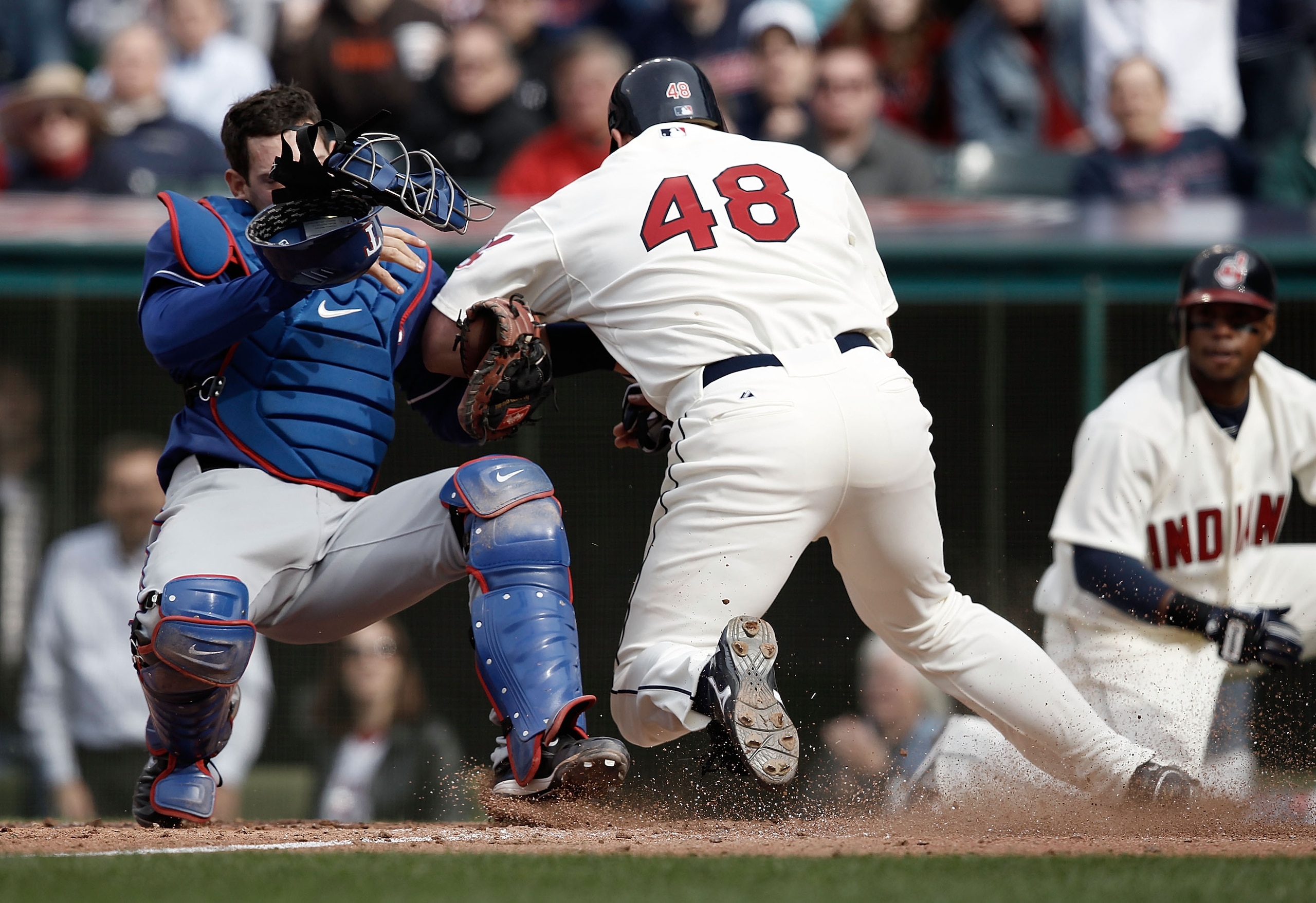 CLEVELAND, OH- APRIL 12: Taylor Teagarden #2 of the Texas Rangers tags out Travis Hafner #48 of the Cleveland Indians while colliding with him at home plate during the Opening Day game on April 12, 2010 at Progressive Field in Cleveland, Ohio.  (Photo by