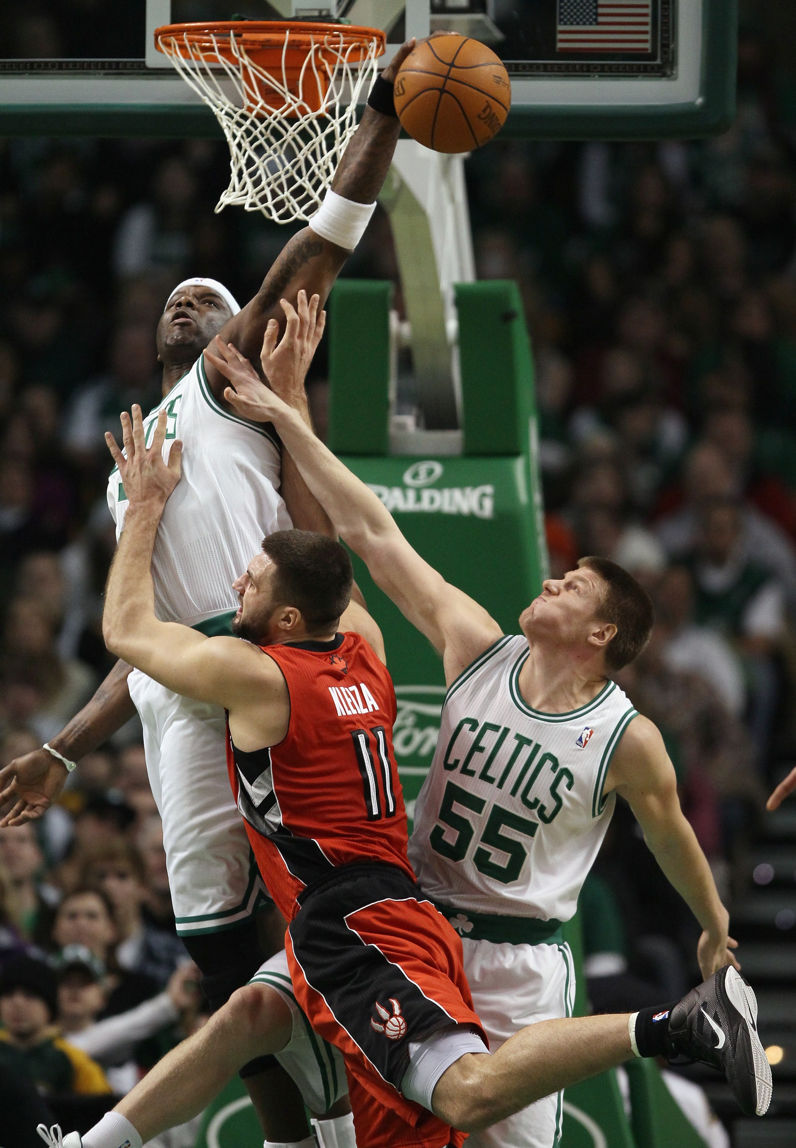 BOSTON, MA - JANUARY 07:  Jermaine O'Neal #7 of the Boston Celtics blocks a shot by Linas Kleiza #11  of the Toronto Raptors as Luke Harangody #55 of the Celtics fouls on January 7, 2011 at the TD Garden in Boston, Massachusetts. NOTE TO USER: User expres