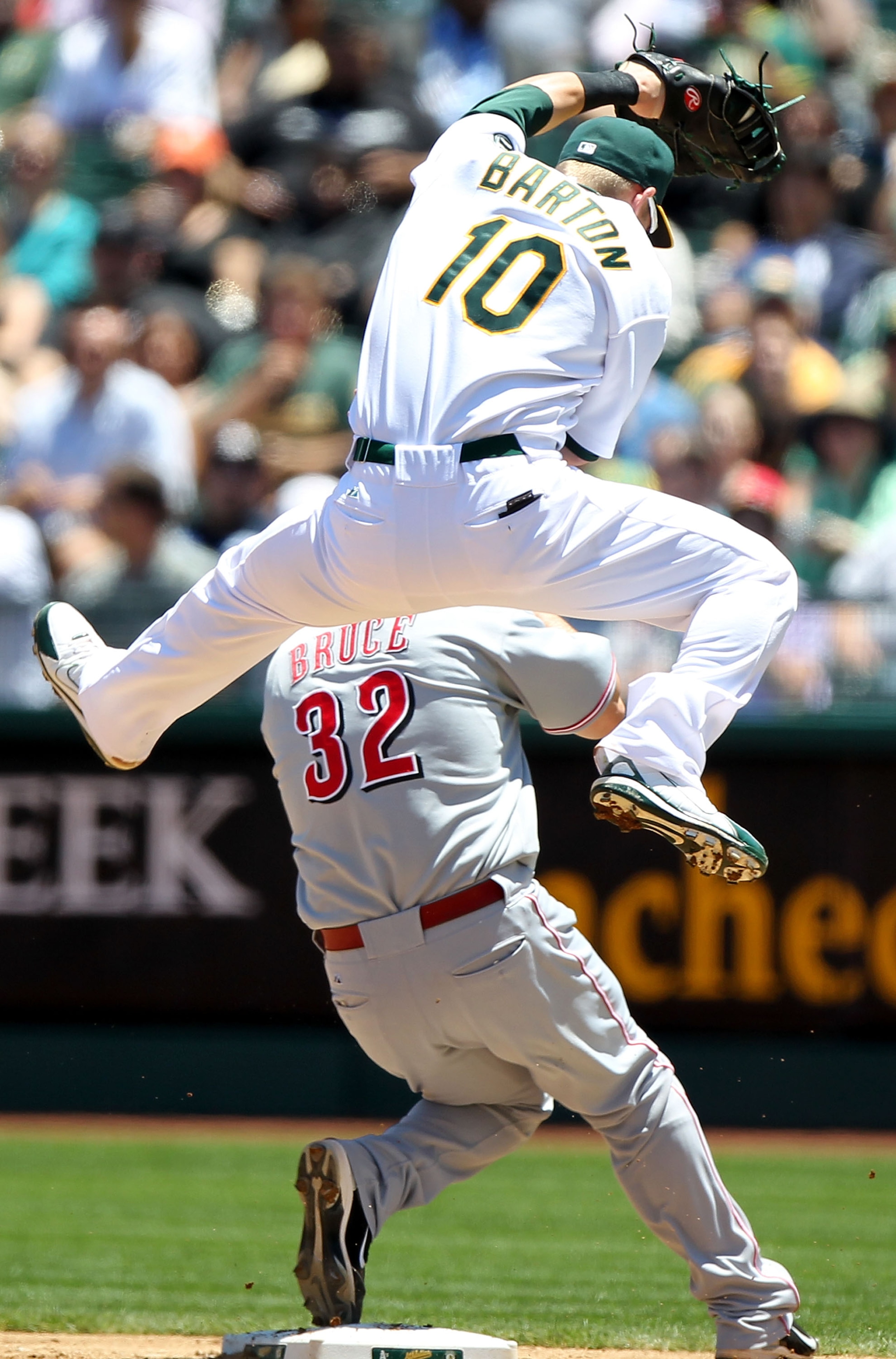 OAKLAND, CA - JUNE 23:  Daric Barton #10 of the Oakland Athletics leaps for a overthrown ball as Jay Bruce #32 of of the Cincinnati Reds looks on during an MLB game at the Oakland-Alameda County Coliseum on June 23, 2010 in Oakland, California. (Photo by