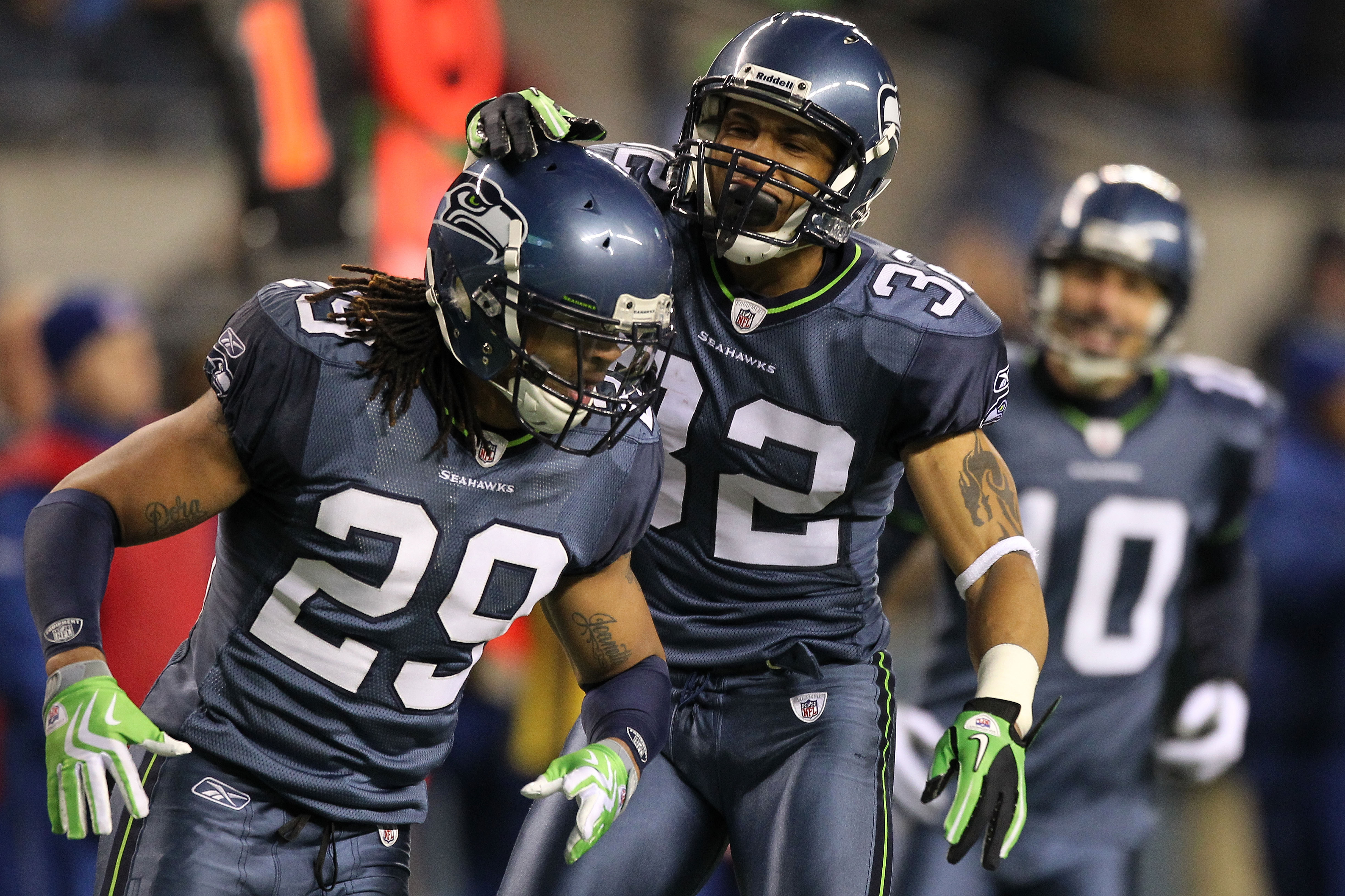 Seattle Seahawks' Lawyer Milloy, right, talks with Marcus Brown on