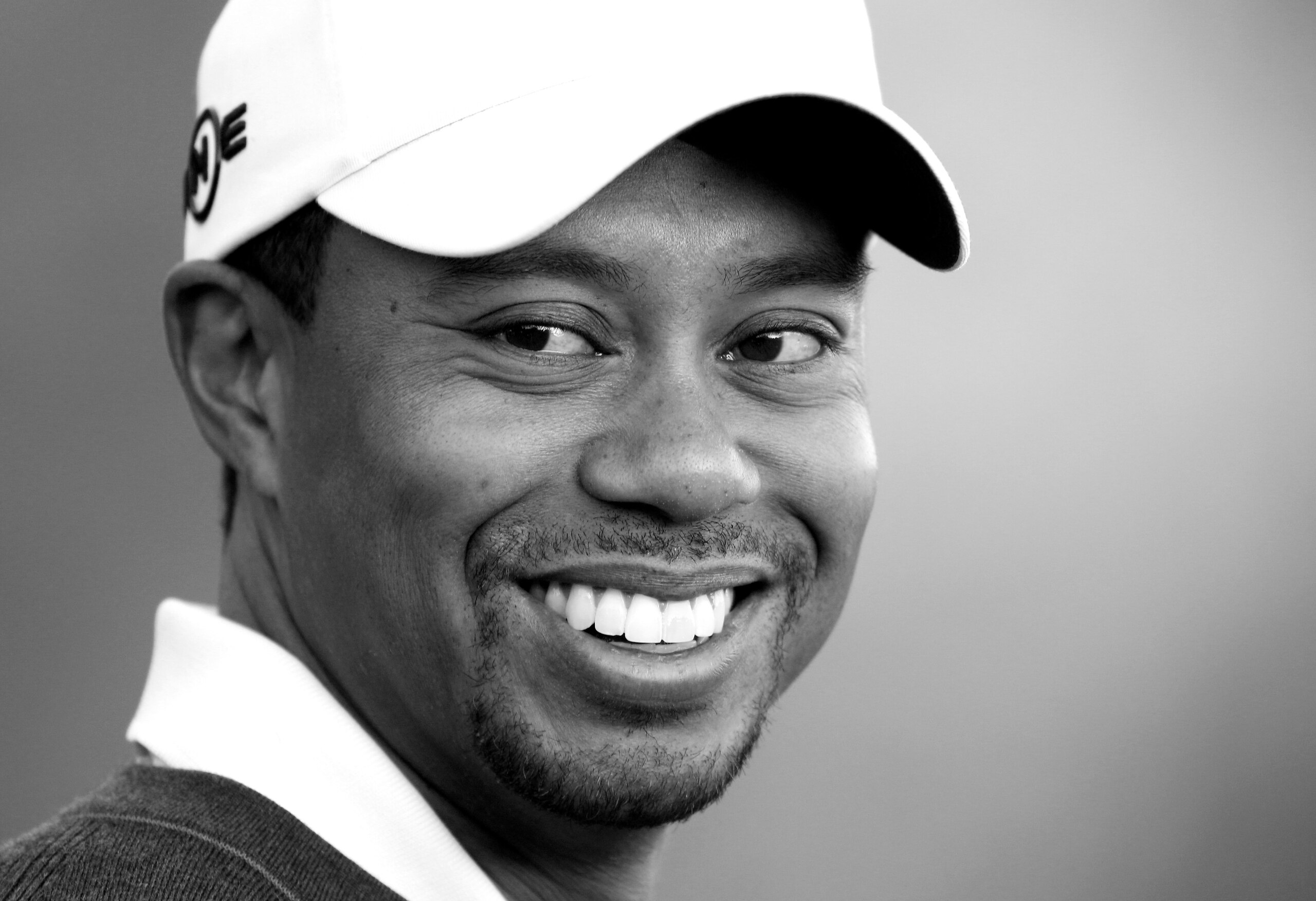CHARLOTTE, NC - APRIL 28:  (EDITORS NOTE: THIS IMAGE HAS BEEN CONVERTED TO BLACK & WHITE) Tiger Woods smiles as he warms up on the practice range during the pro-am for the Quail Hollow Championship at Quail Hollow Country Club on April 28, 2010 in Charlot