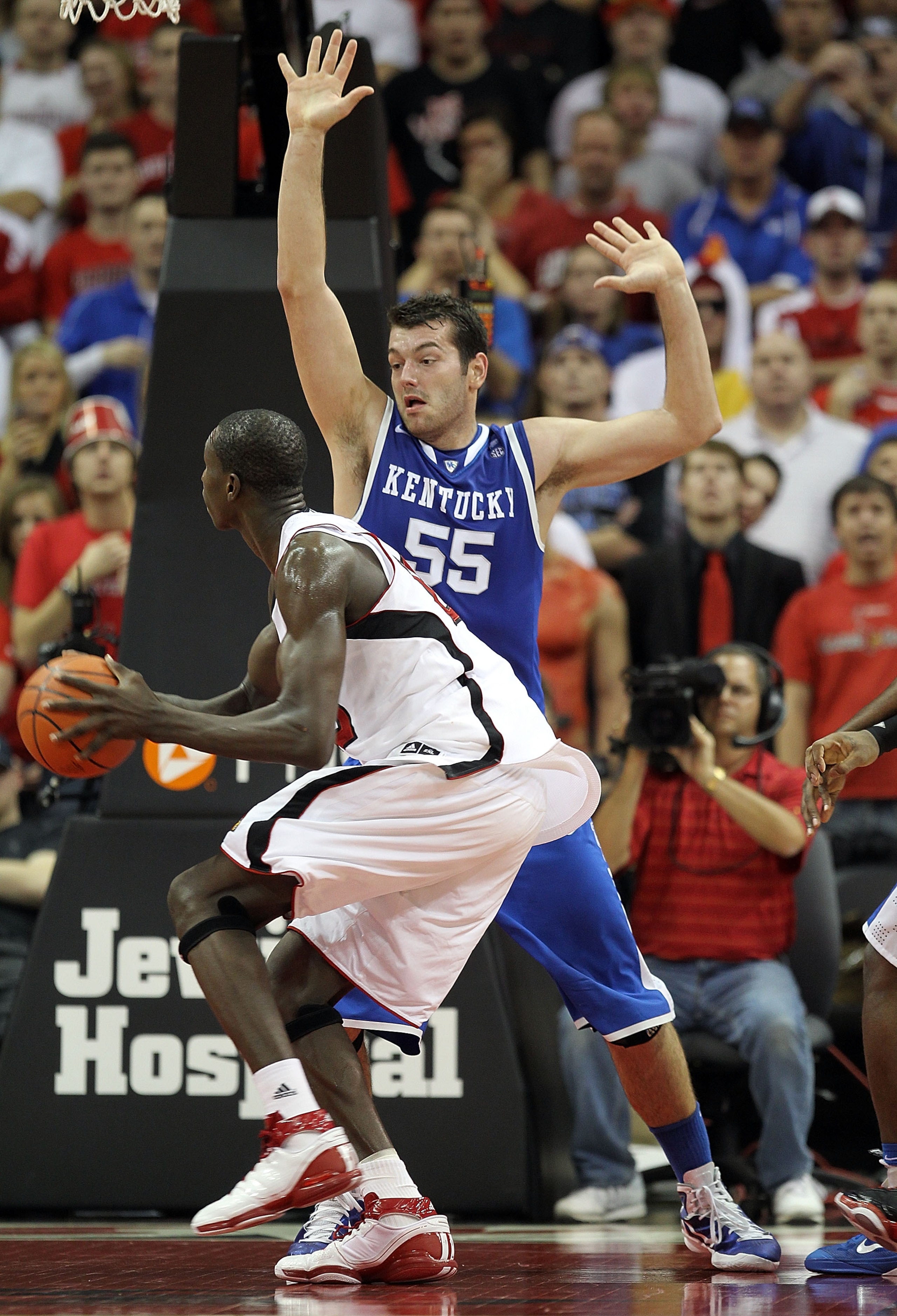 LOUISVILLE, KY - DECEMBER 31:  Josh Harrellson#55 of the Kentucky Wildcats defendes Gorgui Dieng #10 of the Louisville Cardinals during the game at the KFC Yum! Center on December 31, 2010 in Louisville, Kentucky. Kentucky won 78-63.  (Photo by Andy Lyons