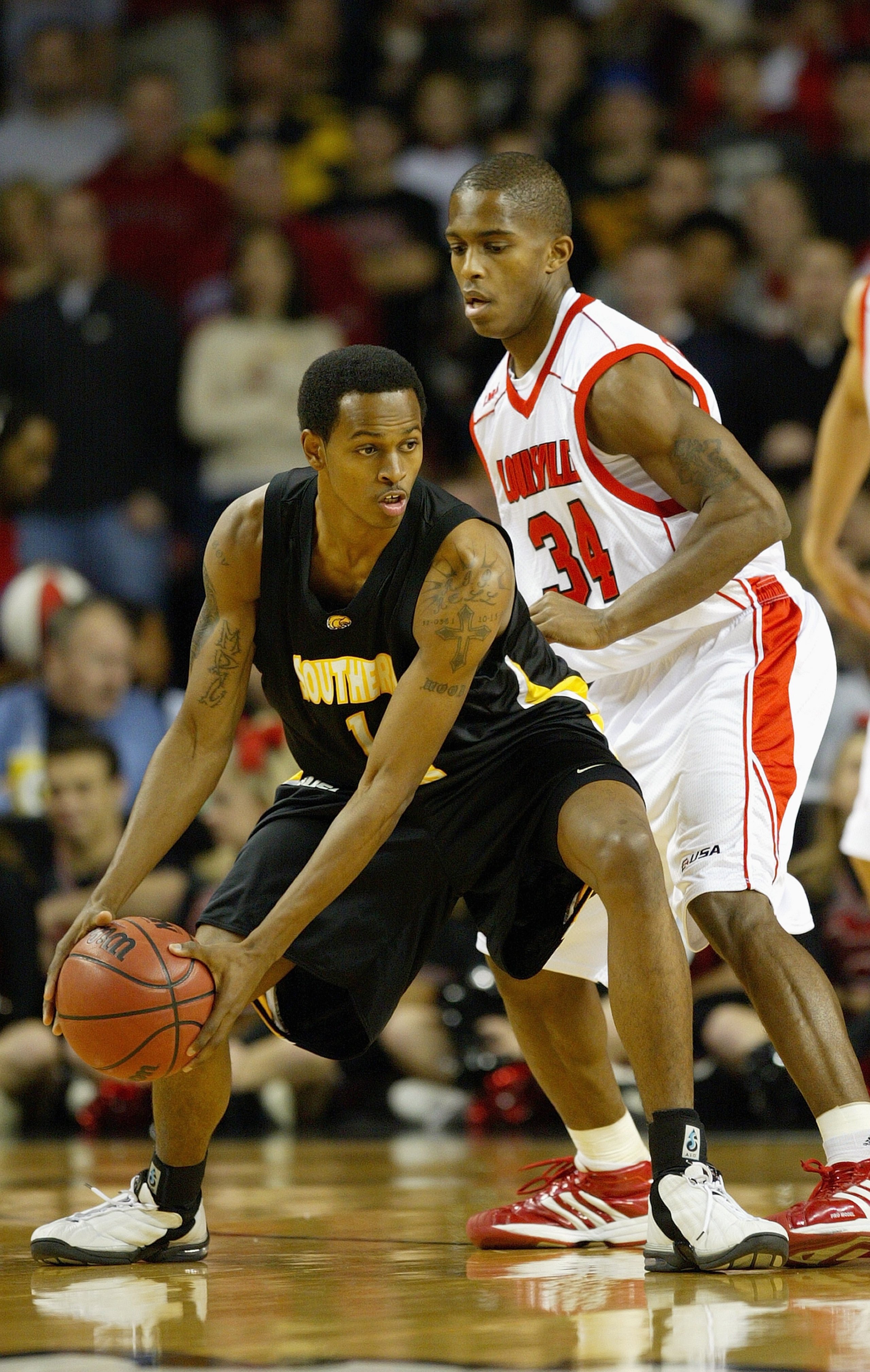 LOUISVILLE, KENTUCKY - JANUARY 7:  David Haywood #1 of the Southern Mississippi Golden Eagles holds the ball as he is covered by Larry O'Bannon #34 of the Louisville Cardinals on January 7, 2004 at Freedom Hall in Louisville, Kentucky. The Cardinals won 7
