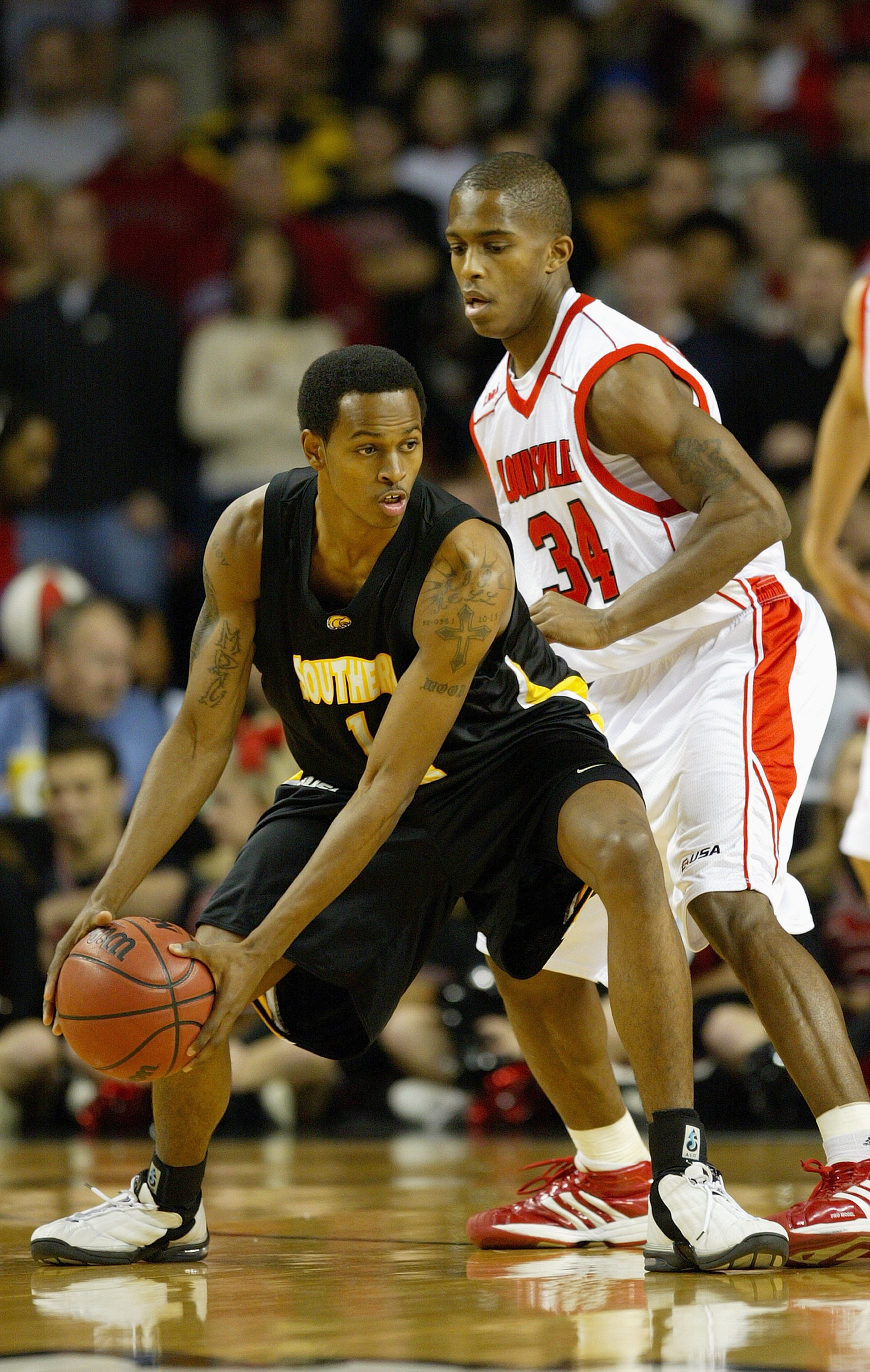 LOUISVILLE, KENTUCKY - JANUARY 7:  David Haywood #1 of the Southern Mississippi Golden Eagles holds the ball as he is covered by Larry O'Bannon #34 of the Louisville Cardinals on January 7, 2004 at Freedom Hall in Louisville, Kentucky. The Cardinals won 7