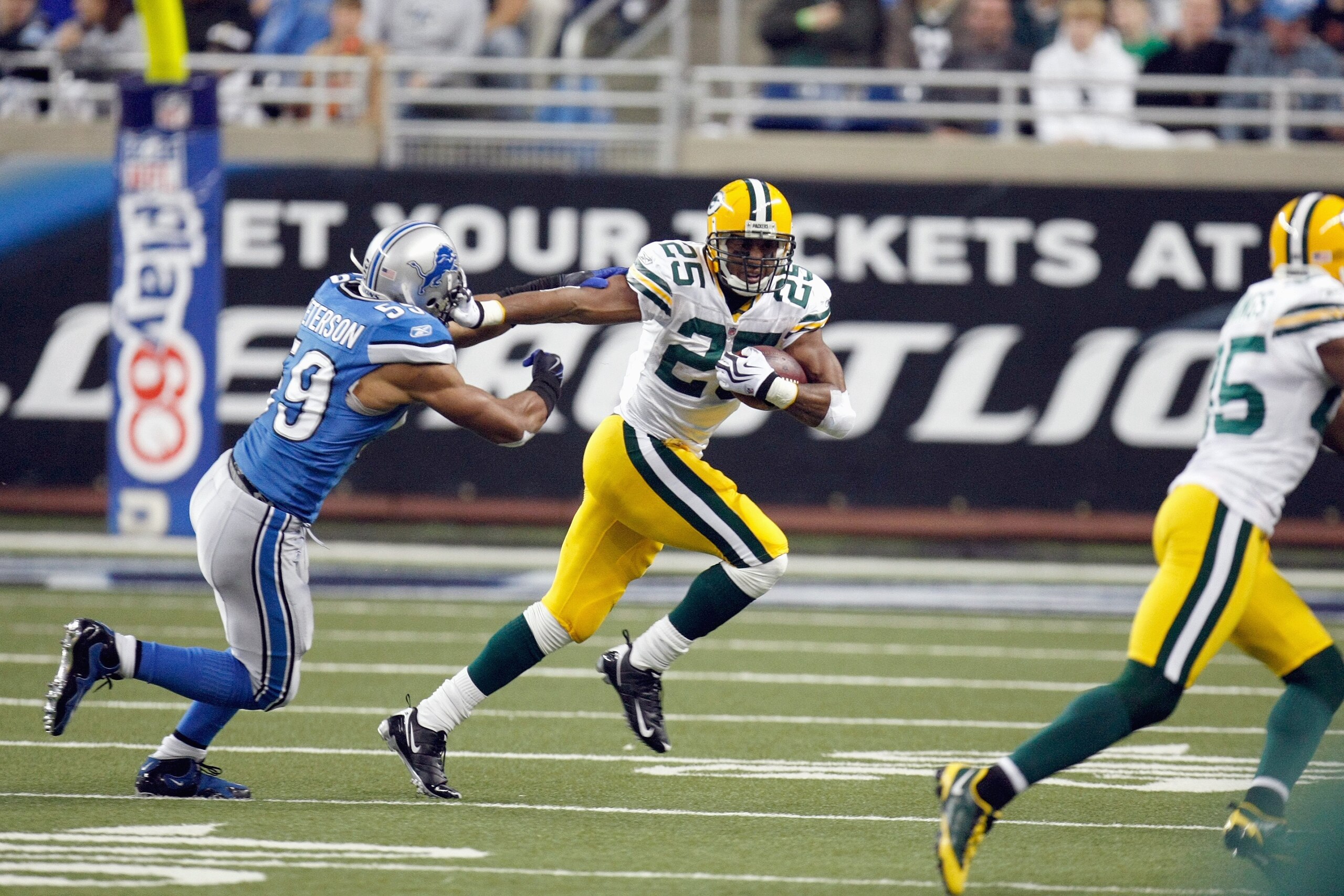 DETROIT , MI - NOVEMBER 26:  Ryan Grant #25 of the Green Bay Packers carries the ball against Julian Peterson #59 of the Detroit Lions on November 26, 2009 at Ford Field in Detroit, Michigan. Green Bay won the game 34-12. (Photo by Gregory Shamus/Getty Im