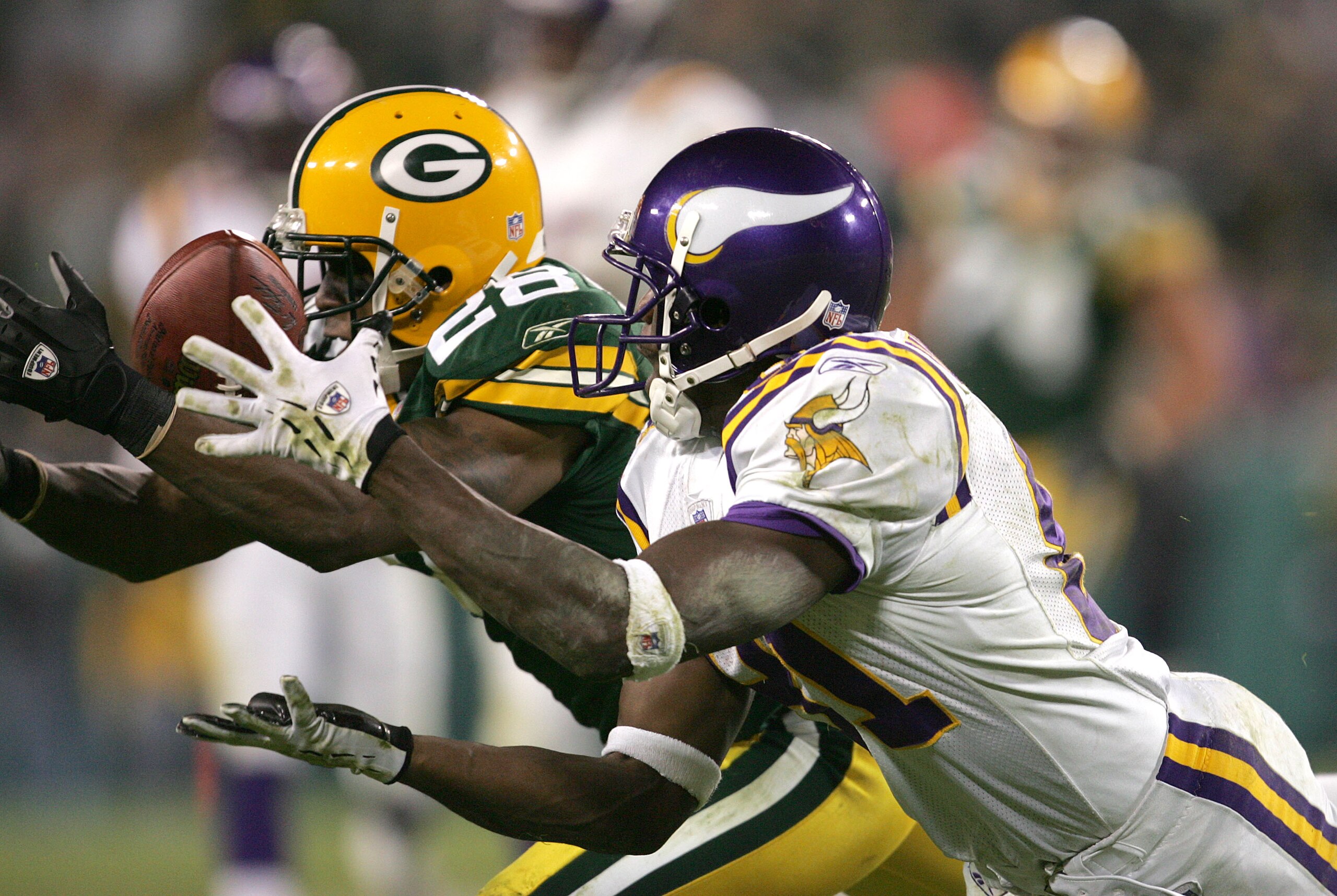 GREEN BAY, WI - NOVEMBER 14: Ahmad Carroll #28 of the Green Bay Packers breaks up a pass intended for Nate Burleson #81 of the Minnesota Vikings during a game at Lambeau Field on November 14, 2004 in Green Bay, Wisconsin. The Packers defeated the Vikings