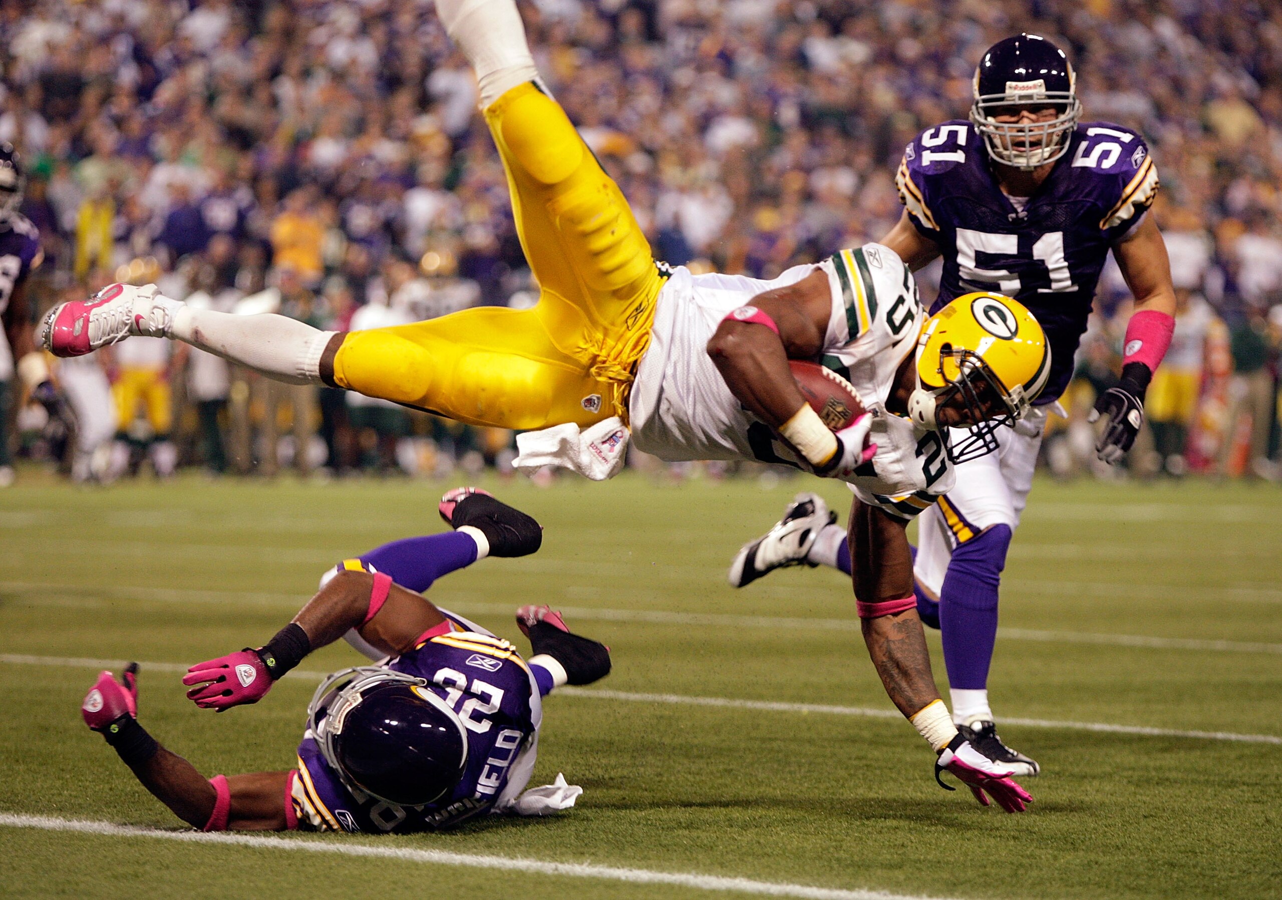 MINNEAPOLIS - OCTOBER 05:  Running back Ryan Grant #25 of the Green Bay Packers is upended by Antoine Winfield #26 of the Minnesota Vikings as Ben Leber #51 looks on during the Monday Night Football game on October 5, 2009 at Hubert H. Humphrey Metrodome