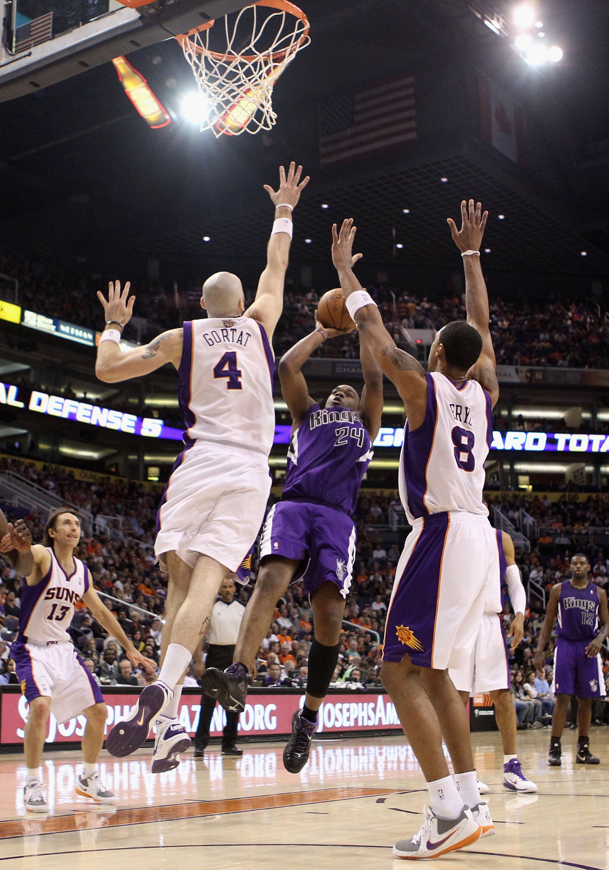 PHOENIX, AZ - FEBRUARY 13:  Carl Landry #24 of the Sacramento Kings puts up a shot against Marcin Gortat #4 and Channing Frye #8 of the Phoenix Suns during the NBA game at US Airways Center on February 13, 2011 in Phoenix, Arizona. The Kings defeated the