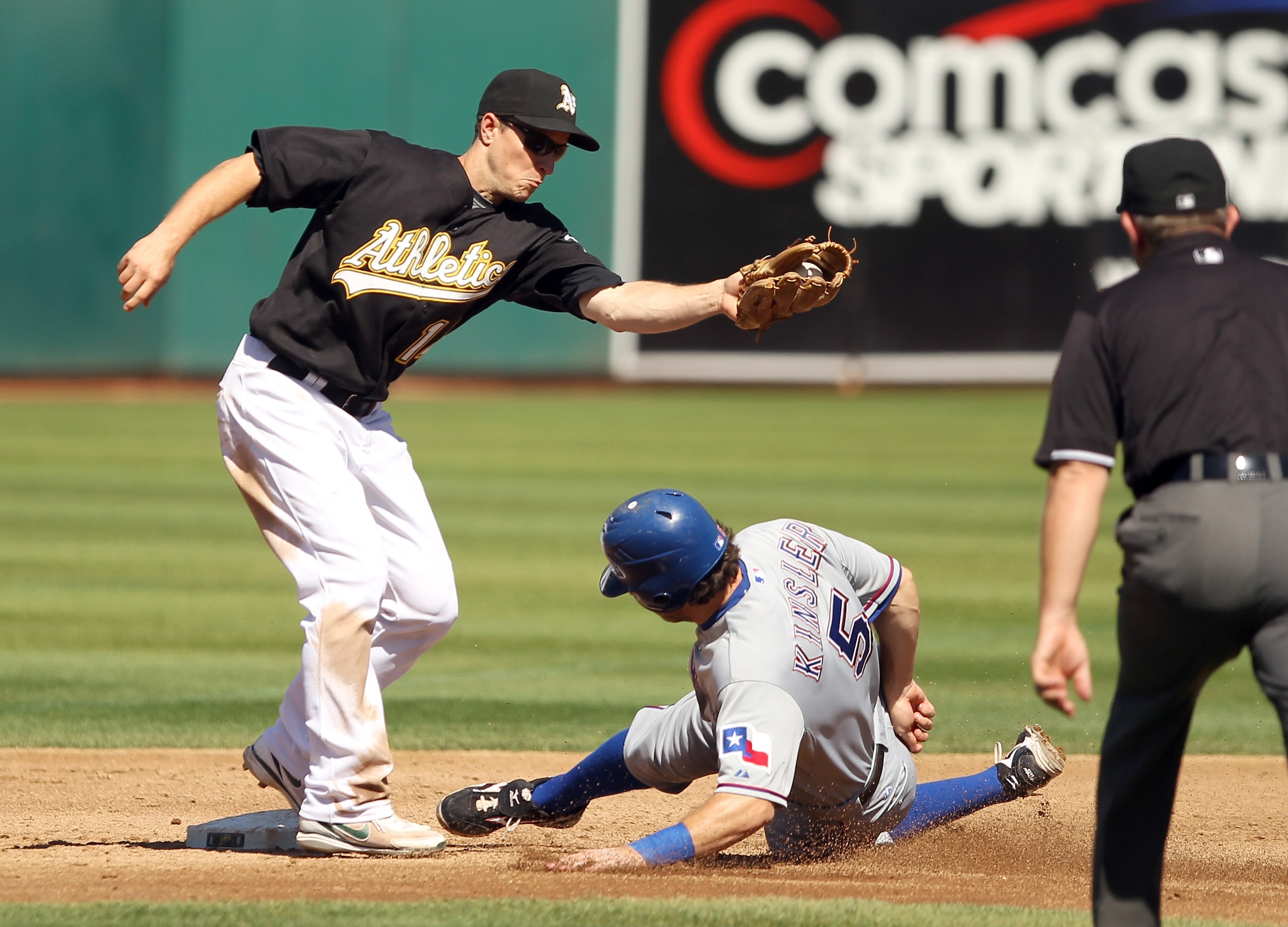 OAKLAND, CA - SEPTEMBER 25:  Ian Kinsler #5 of the Texas Rangers safely slides under the tag of Mark Ellis #14 of the Oakland Athletics to steal second base at the Oakland-Alameda County Coliseum on September 25, 2010 in Oakland, California.  (Photo by Ez