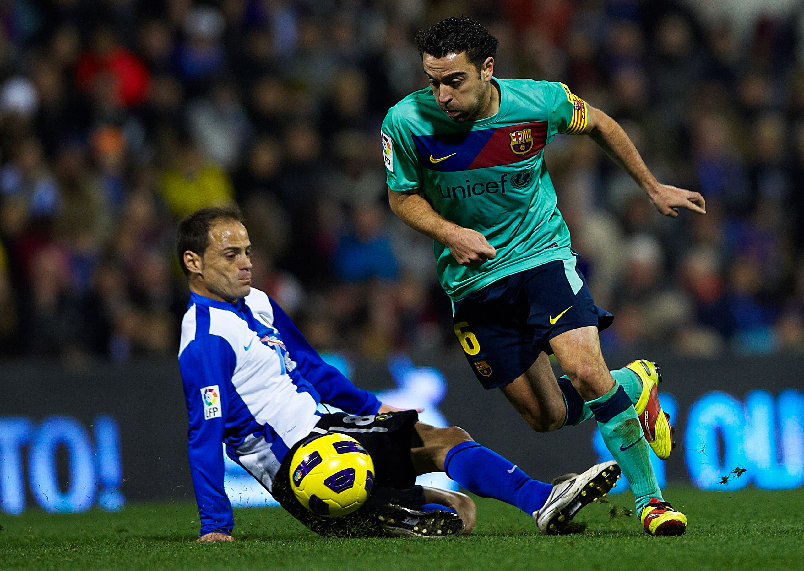 ALICANTE, SPAIN - JANUARY 29:  Xavi Hernandez (R) of Barcelona duels for the ball with Farinos of Hercules during the la Liga match between Hercules and Barcelona at Estadio Jose Rico Perez on January 29, 2011 in Alicante, Spain. Barcelona won 0-3.  (Phot