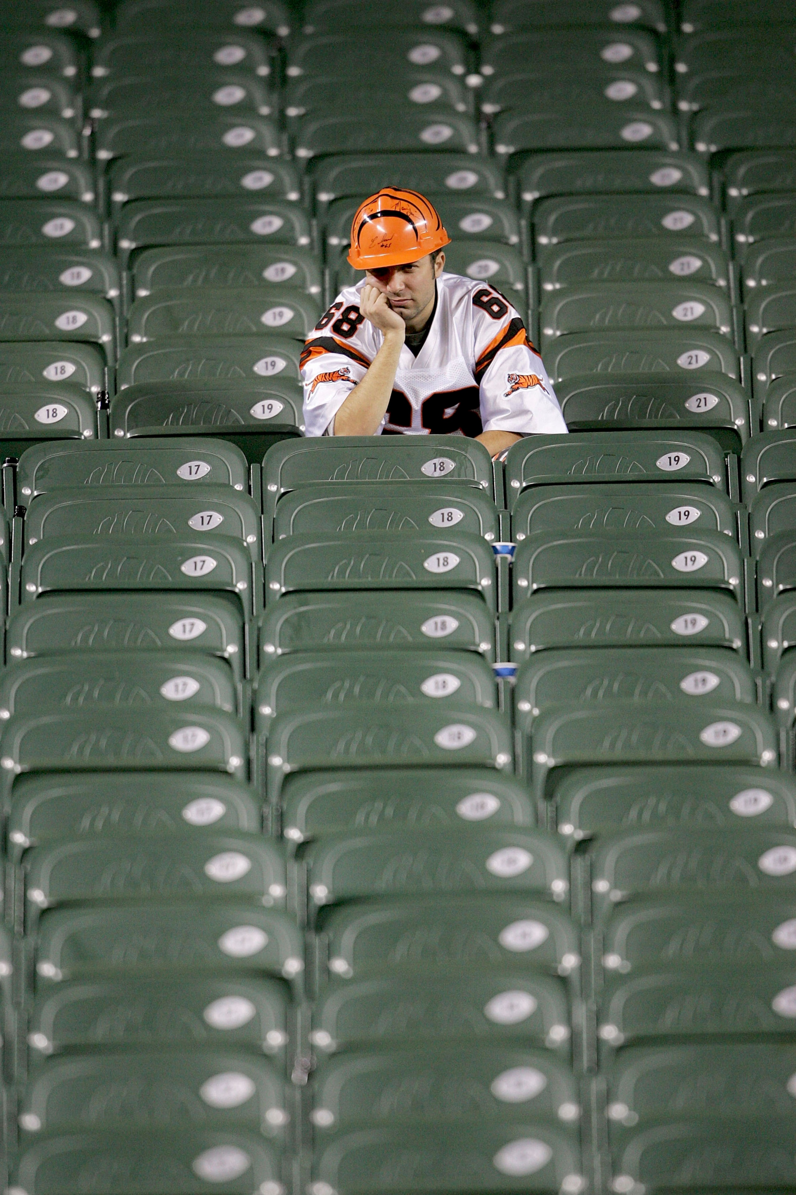 CINCINNATI - JANUARY 8: A fan of the Cincinnati Bengals sits dejected in the stands after the Bengals lost the AFC Wild Card Playoff Game to the Pittsburgh Steelers at Paul Brown Stadium on January 8, 2006 in Cincinnati, Ohio. The Steelers won 31-17 and CINCINNATI - JANUARY 8: A fan of the Cincinnati Bengals sits dejected in the stands after the Bengals lost the AFC Wild Card Playoff Game to the Pittsburgh Steelers at Paul Brown Stadium on January 8, 2006 in Cincinnati, Ohio. The Steelers won 31-17 and