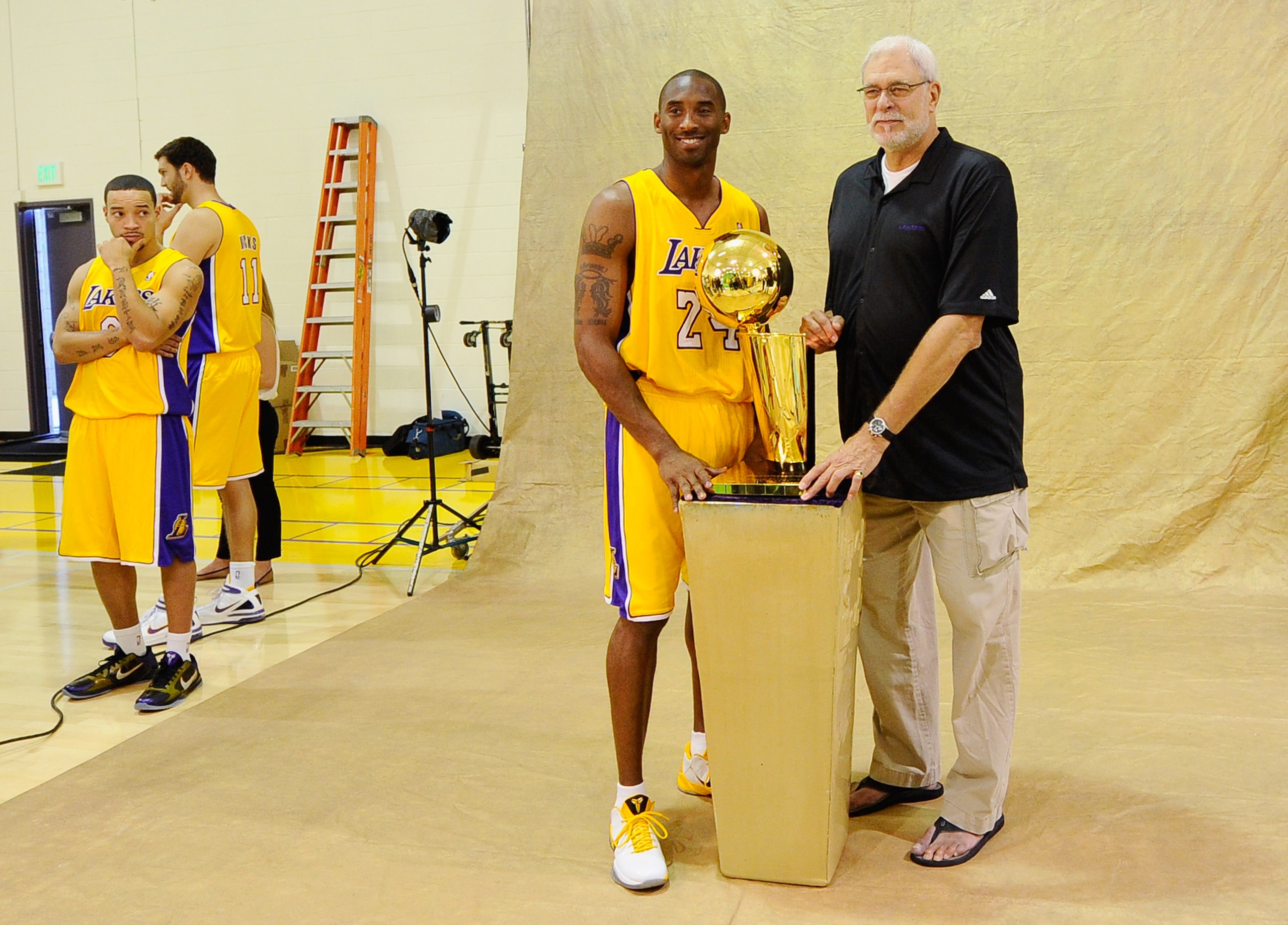 EL SEGUNDO, CA - SEPTEMBER 25:  Kobe Bryant #24 and head coach Phil Jackson of the Los Angeles Lakers pose with NBA Finals Larry O'Brien Championship Trophy as teammate Anthony Rob erson #0 looks on during Media Day at the Toyota Center on September 25, 2