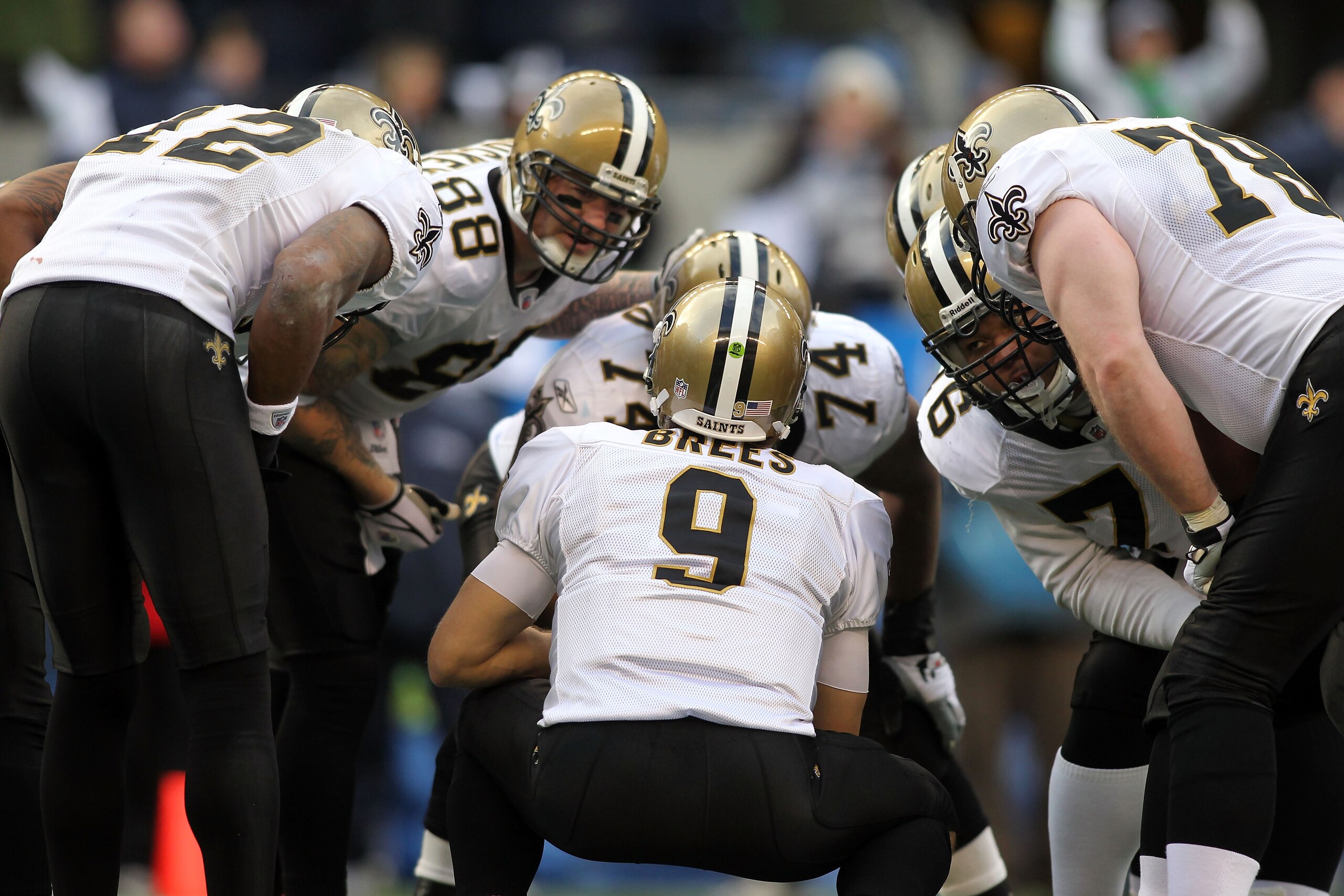 SEATTLE, WA - JANUARY 08:  Quarterback Drew Brees #9 of the New Orleans Saints kneels down in the huddle in the second quarter against the Seattle Seahawks during the 2011 NFC wild-card playoff game at Qwest Field on January 8, 2011 in Seattle, Washington