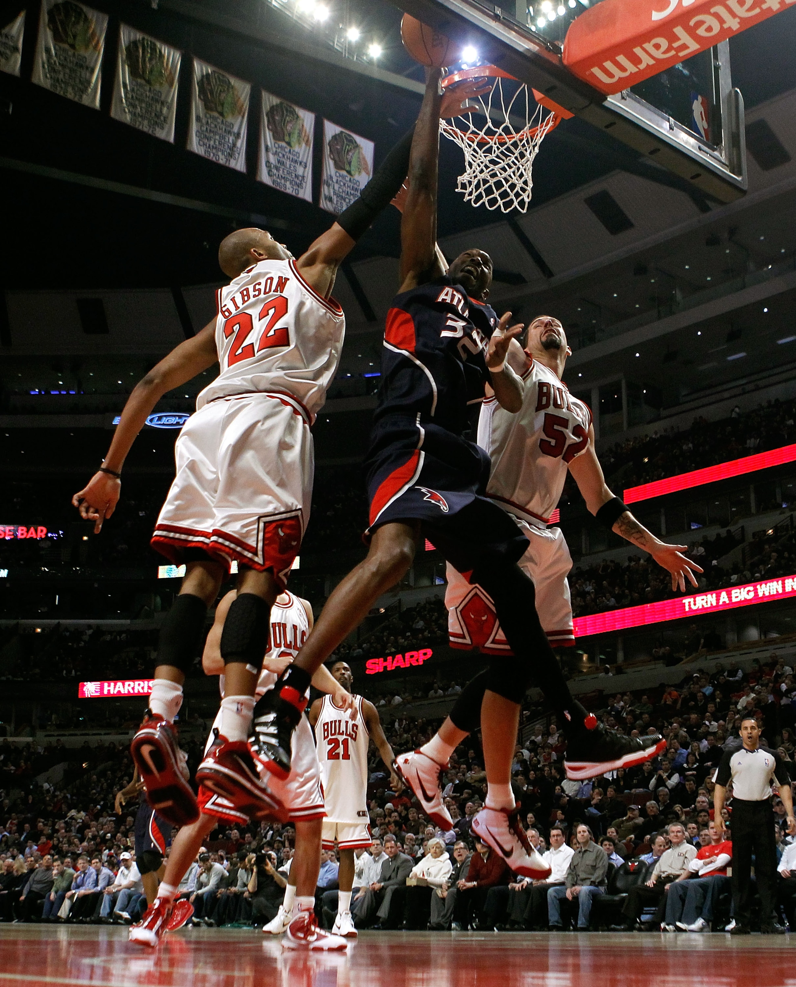 CHICAGO - MARCH 01: Joe Smith #32 of the Atlanta Hawks puts up a shot between Taj Gibson #22 and Brad Miller #52 of the Chicago Bulls at the United Center on March 1, 2010 in Chicago, Illinois. NOTE TO USER: User expressly acknowledges and agrees that, by
