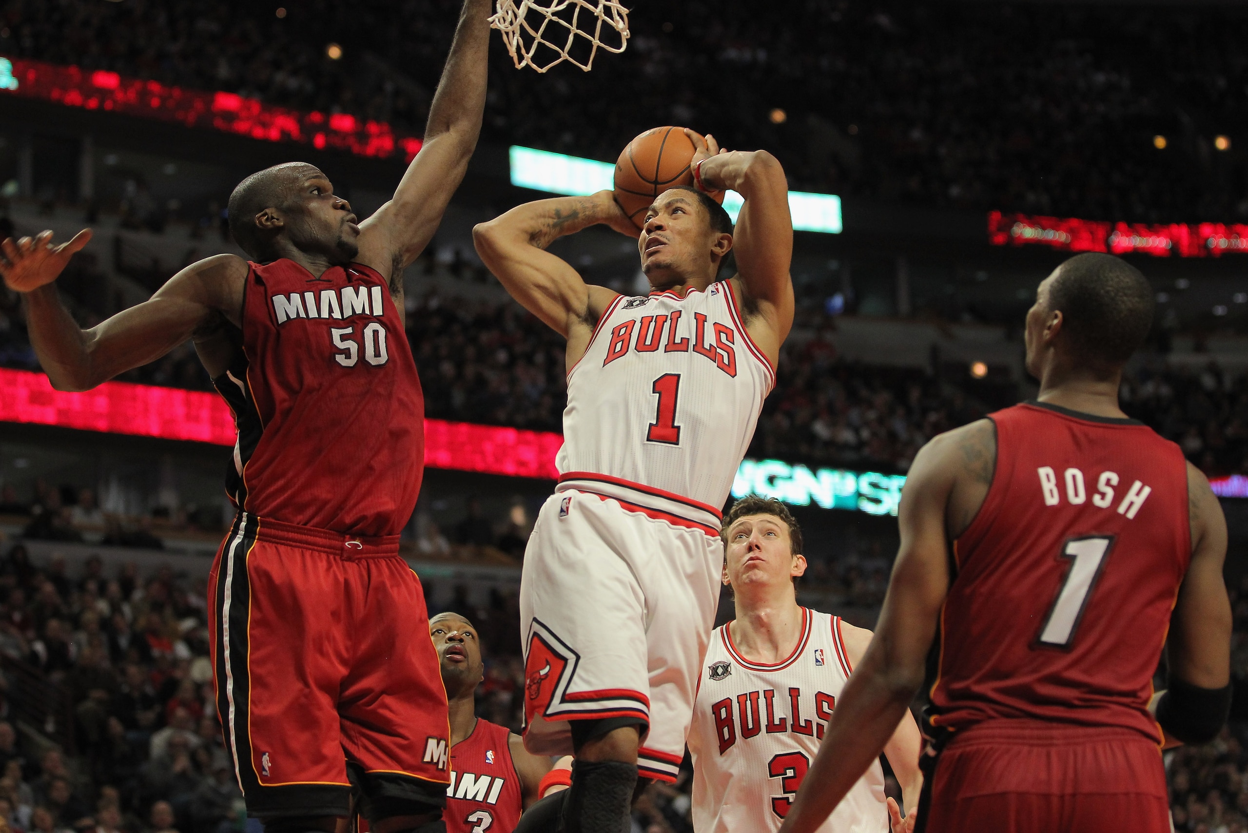 CHICAGO, IL - JANUARY 15:  Derrick Rose #1 of the Chicago Bulls gets off a shot as he is fouled by Joel Anthony #50 of the Miami Heat while Chris Bosh #1 of the Heat follows the action at the United Center on January 15, 2011 in Chicago, Illinois. NOTE TO