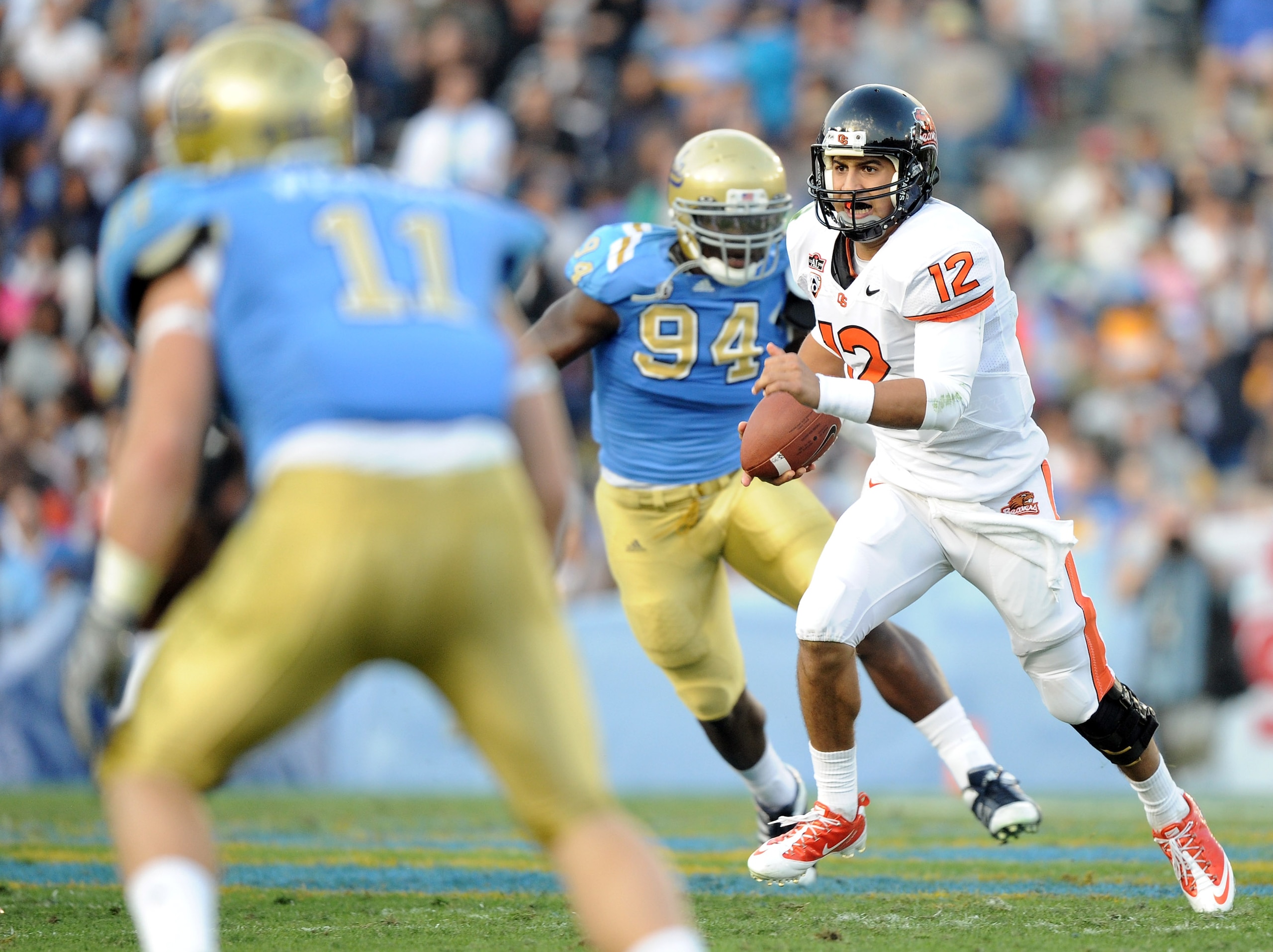PASADENA, CA - NOVEMBER 06:  Ryan Katz #12 of the Oregon State Beavers runs out of the pocket as he is chased by Owamagbe Odighizuwa #94 of the UCLA Bruins during the second quarter at the Rose Bowl on November 6, 2010 in Pasadena, California.  (Photo by