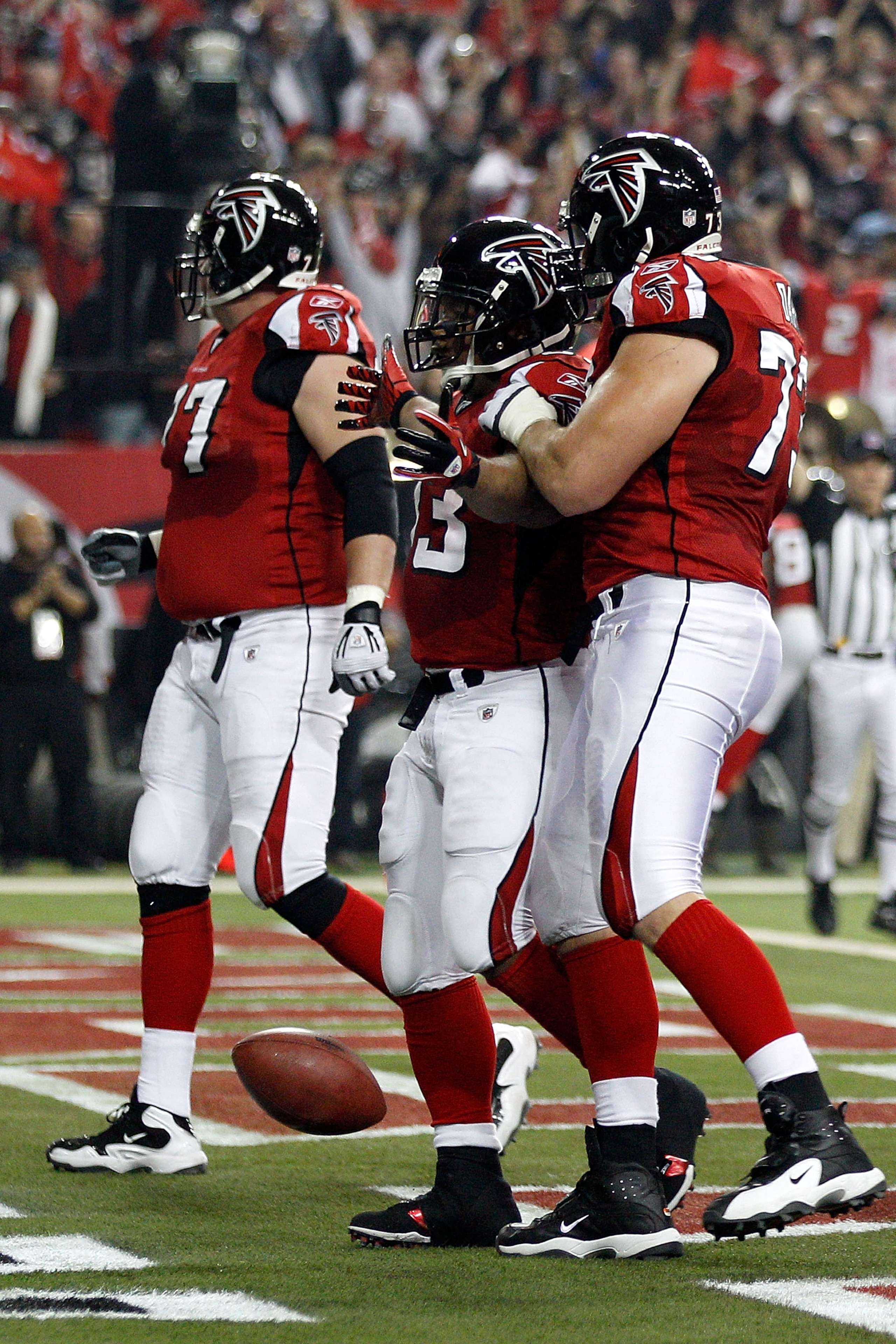ATLANTA, GA - JANUARY 15:  (L-R) Tyson Clabo #77, Michael Turner #33 and Harvey Dahl #73 of the Atlanta Falcons celebrate after Turner scored a 12-yard rushing touchdown in the first quarter against the Green Bay Packers during their 2011 NFC divisional p