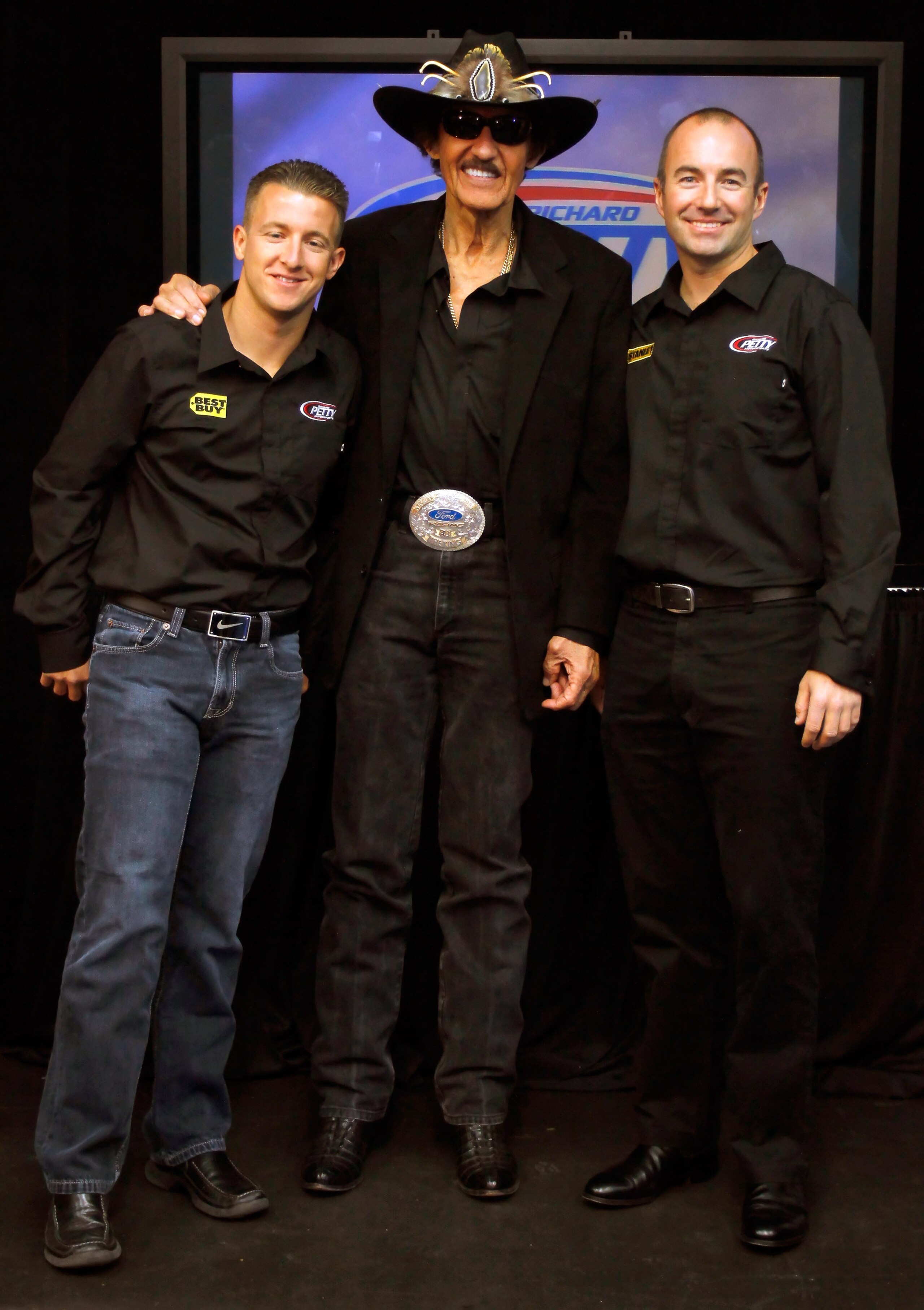 CONCORD, NC - JANUARY 26: NASCAR Hall of Famer and team owner Richard Petty (C), poses with AJ Allmendinger (L), driver of the #43 Best Buy Ford, and Marcos Ambrose (R), driver of the #9 Stanley Tools Ford, during the NASCAR Sprint Media Tour hosted by C CONCORD, NC - JANUARY 26: NASCAR Hall of Famer and team owner Richard Petty (C), poses with AJ Allmendinger (L), driver of the #43 Best Buy Ford, and Marcos Ambrose (R), driver of the #9 Stanley Tools Ford, during the NASCAR Sprint Media Tour hosted by C