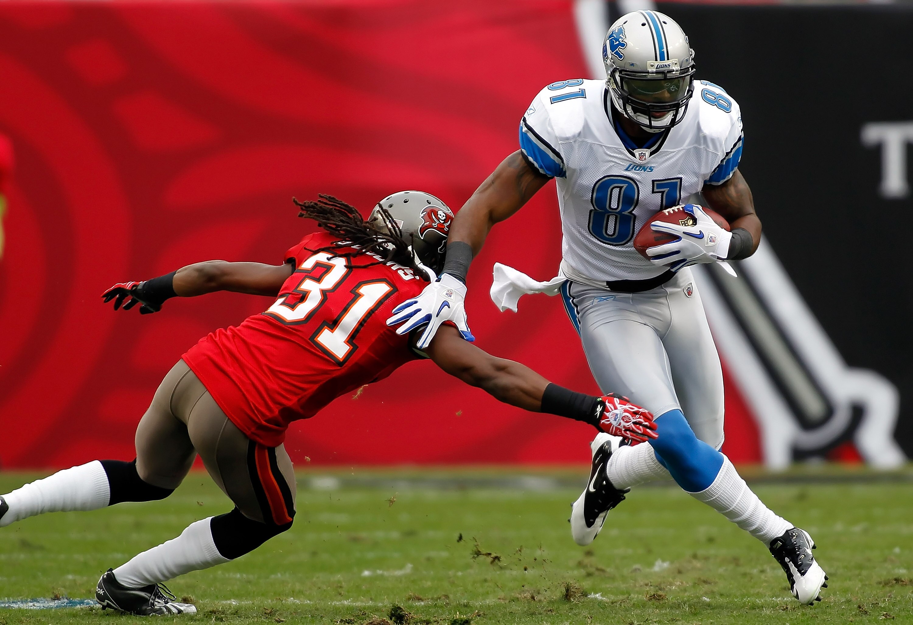 TAMPA, FL - DECEMBER 19:  Receiver Calvin Johnson #81 of the Detroit Lions runs through the tackle of defensive back E.J. Biggers #31 of the Tampa Bay Buccaneers during the game at Raymond James Stadium on December 19, 2010 in Tampa, Florida.  (Photo by J
