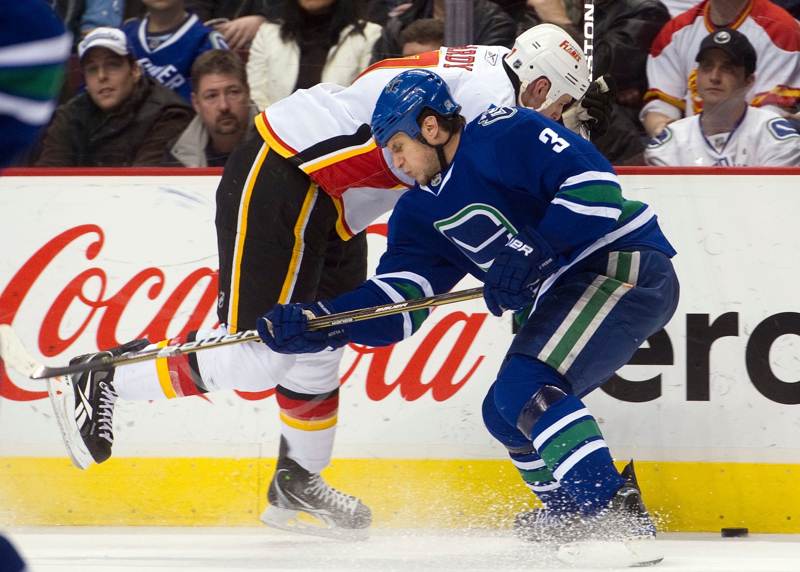 VANCOUVER, CANADA - JANUARY 22: Kevin Bieksa #3 of the Vancouver Canucks delivers a body check to Craig Conroy #24 of the Calgary Flames during the first period in NHL action on January 22, 2011 at Rogers Arena in Vancouver, British Columbia, Canada.  (Ph
