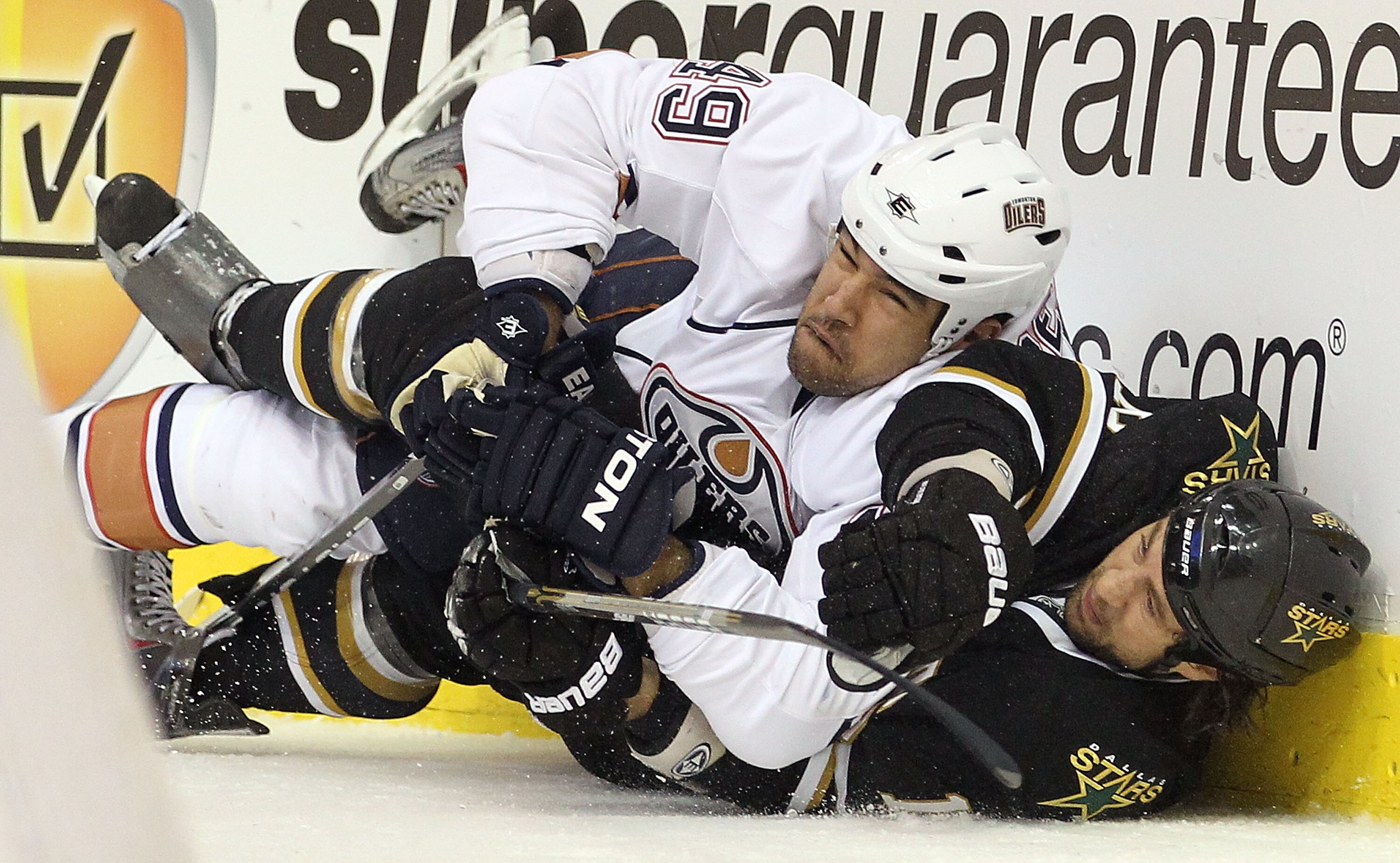 DALLAS, TX - JANUARY 26:  Defenseman Theo Peckham #49 of the Edmonton Oilers falls with Adam Burish #16 of the Dallas Stars at American Airlines Center on January 26, 2011 in Dallas, Texas.  (Photo by Ronald Martinez/Getty Images)