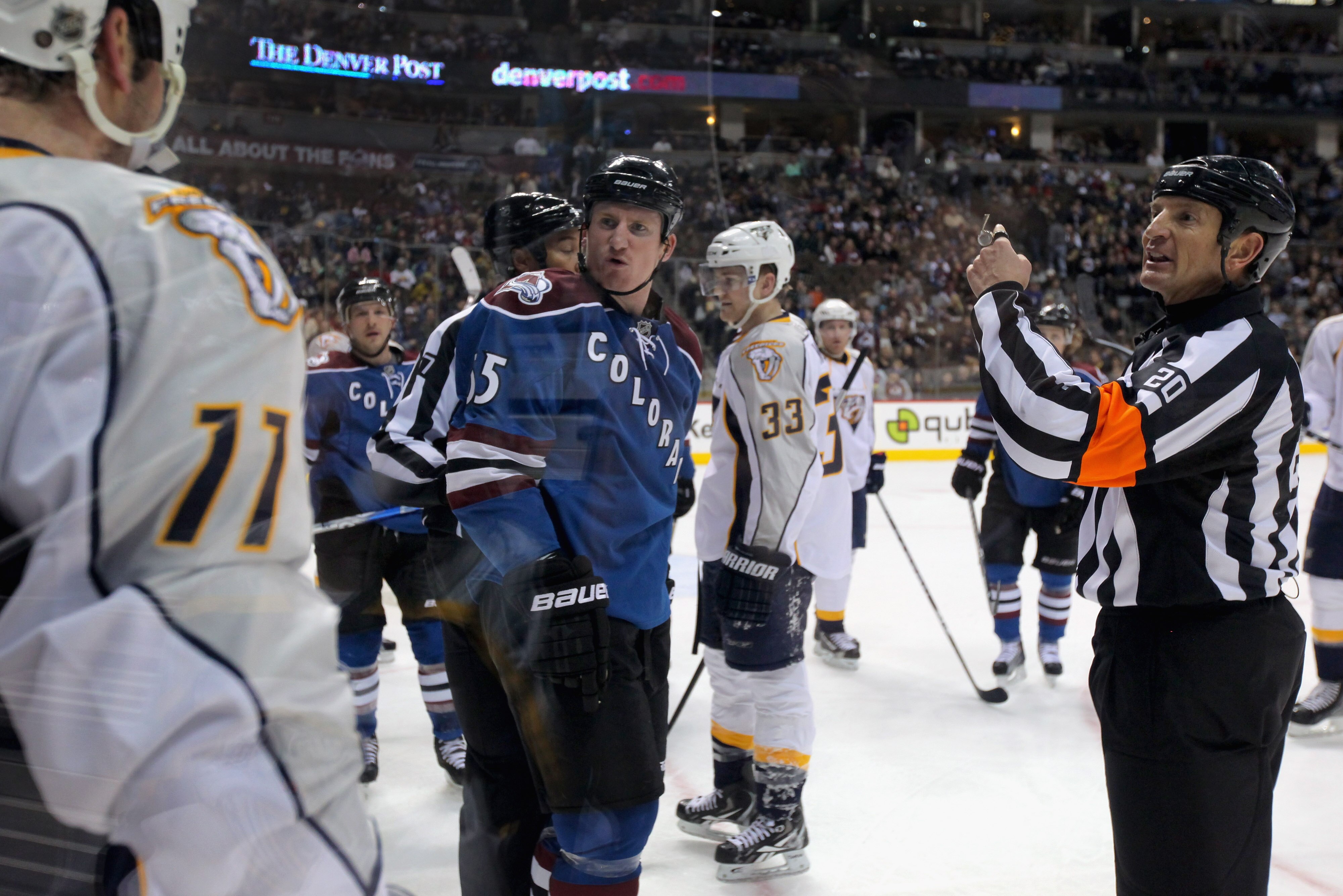 DENVER, CO - JANUARY 20:  Referee Tim Peel #20 makes a penalty call as Cody McLeod #55 of the Colorado Avalanche David Legwand #11 of the Nashville Predators observe at the Pepsi Center on January 20, 2011 in Denver, Colorado.  (Photo by Doug Pensinger/Ge