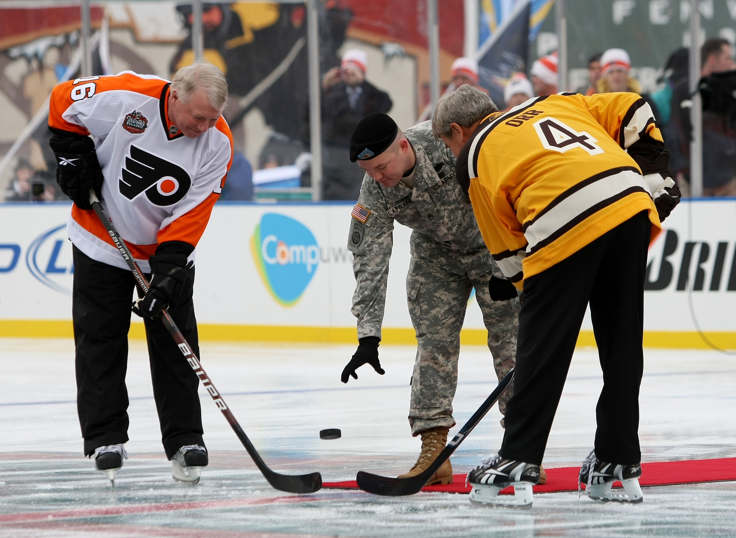 BOSTON - JANUARY 01: Staff Sergeant Ryan R. LaFrance (C) drops the ceremonial first puck for Bobby Clarke #16 (L) honorary captain of the Philadelphia Flyers and Bobby Orr #4 (R) honorary captain of the Boston Bruins during the 2010 Bridgestone Winter Cl BOSTON - JANUARY 01: Staff Sergeant Ryan R. LaFrance (C) drops the ceremonial first puck for Bobby Clarke #16 (L) honorary captain of the Philadelphia Flyers and Bobby Orr #4 (R) honorary captain of the Boston Bruins during the 2010 Bridgestone Winter Cl