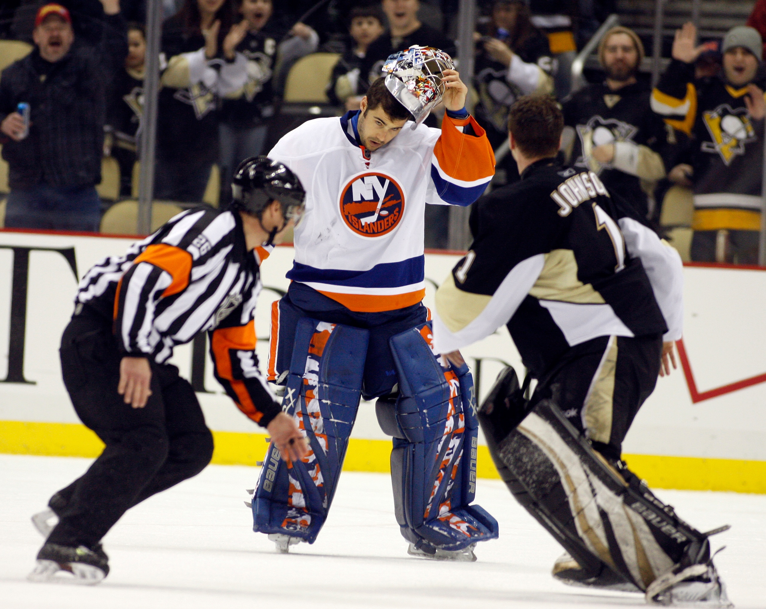 PITTSBURGH, PA - FEBRUARY 02:  Rick DiPietro #39 of the New York Islanders strips off his mask before mixing it up with Brent Johnson #1 of the Pittsburgh Penguins at Consol Energy Center on February 2, 2011 in Pittsburgh, Pennsylvania.  The Penguins shut